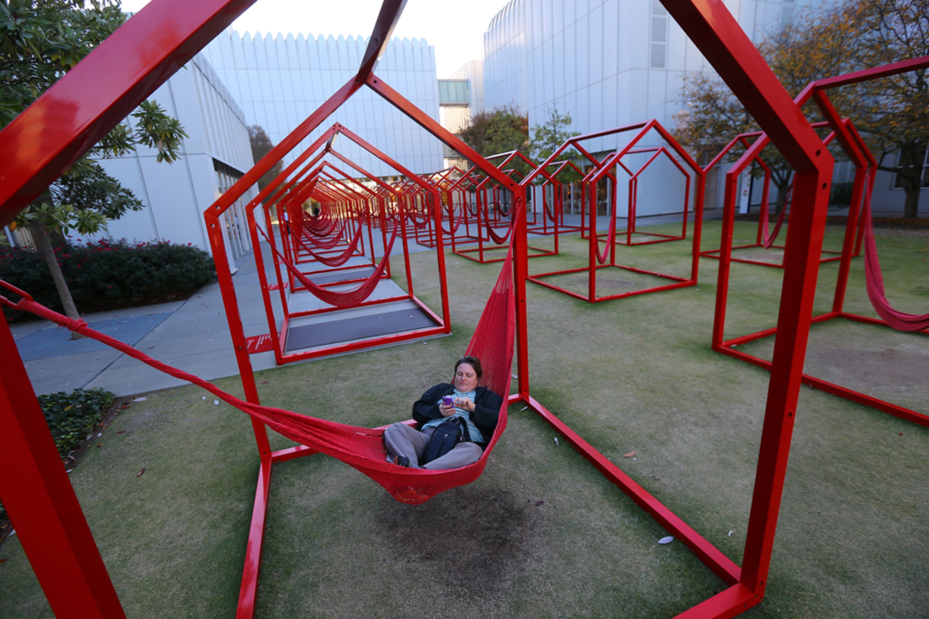 SWINGING IN THE HOUSE--111114 ATLANTA: "Every house has its rules" art displays make for a comfortable place for Jane Chateaubriand, Seattle, to check her email on her phone at Woodruff Arts Center on Tuesday, Nov. 11, 2014, in Atlanta. Woodruff Arts Center is fighting debt, rising expenses, and flat revenues after expansion. CURTIS COMPTON / CCOMPTON@AJC.COM