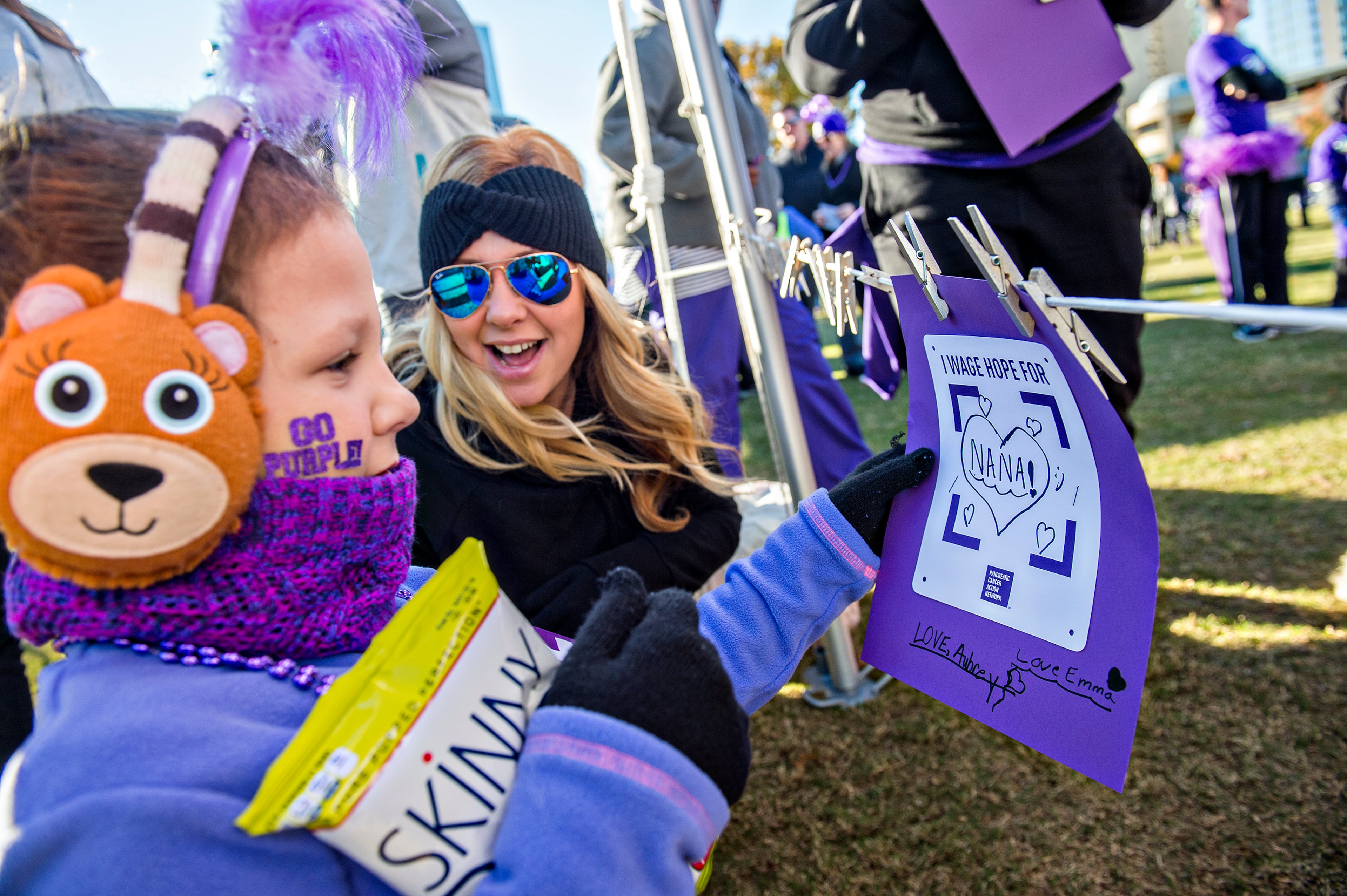 November 14, 2015 Atlanta - Aubrey Carros (left) and hermother Tonya hang a tribute to Aubrey's grandmother before the start of the PurpleStride Atlanta 5k at Centennial Olympic Park in Atlanta on Saturday, November 14, 2015. Participants raised over $265,000 for the Pancreatic Cancer Action Network. JONATHAN PHILLIPS / SPECIAL