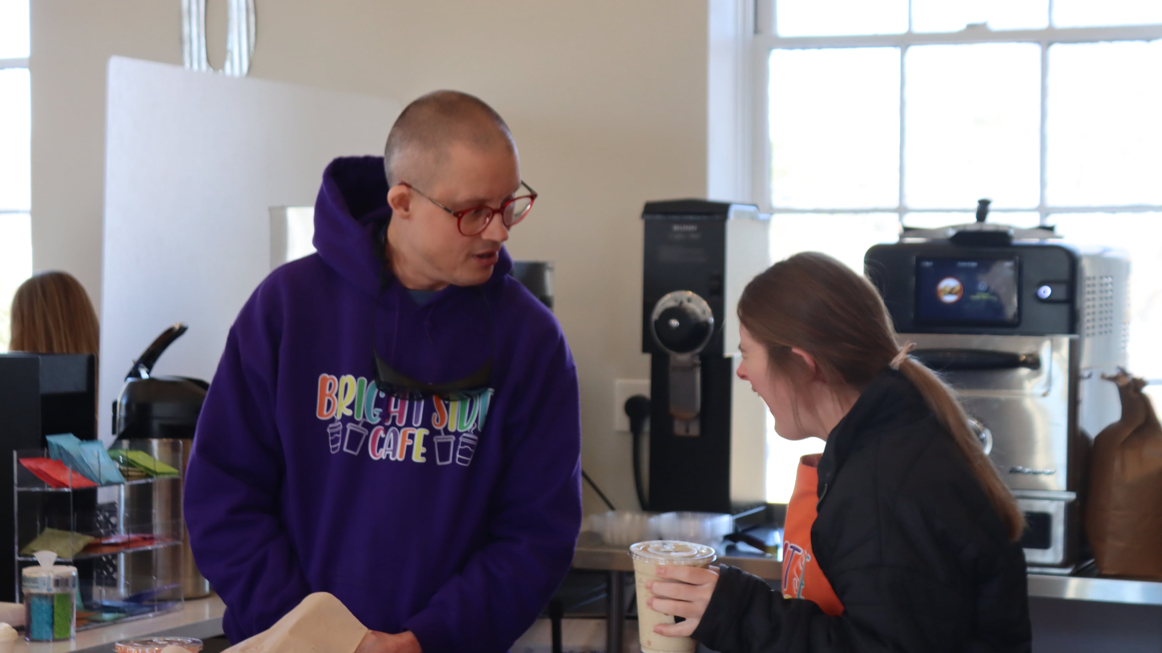 Peter Clark (left) and Ashley McCormick serve coffee drinks and pastries at Brightside Cafe in Buford. Brightside Cafe gives adults with disabilities a place to find success, said co-owner Jennifer Elinburg. (Courtesy of Brightside Cafe)