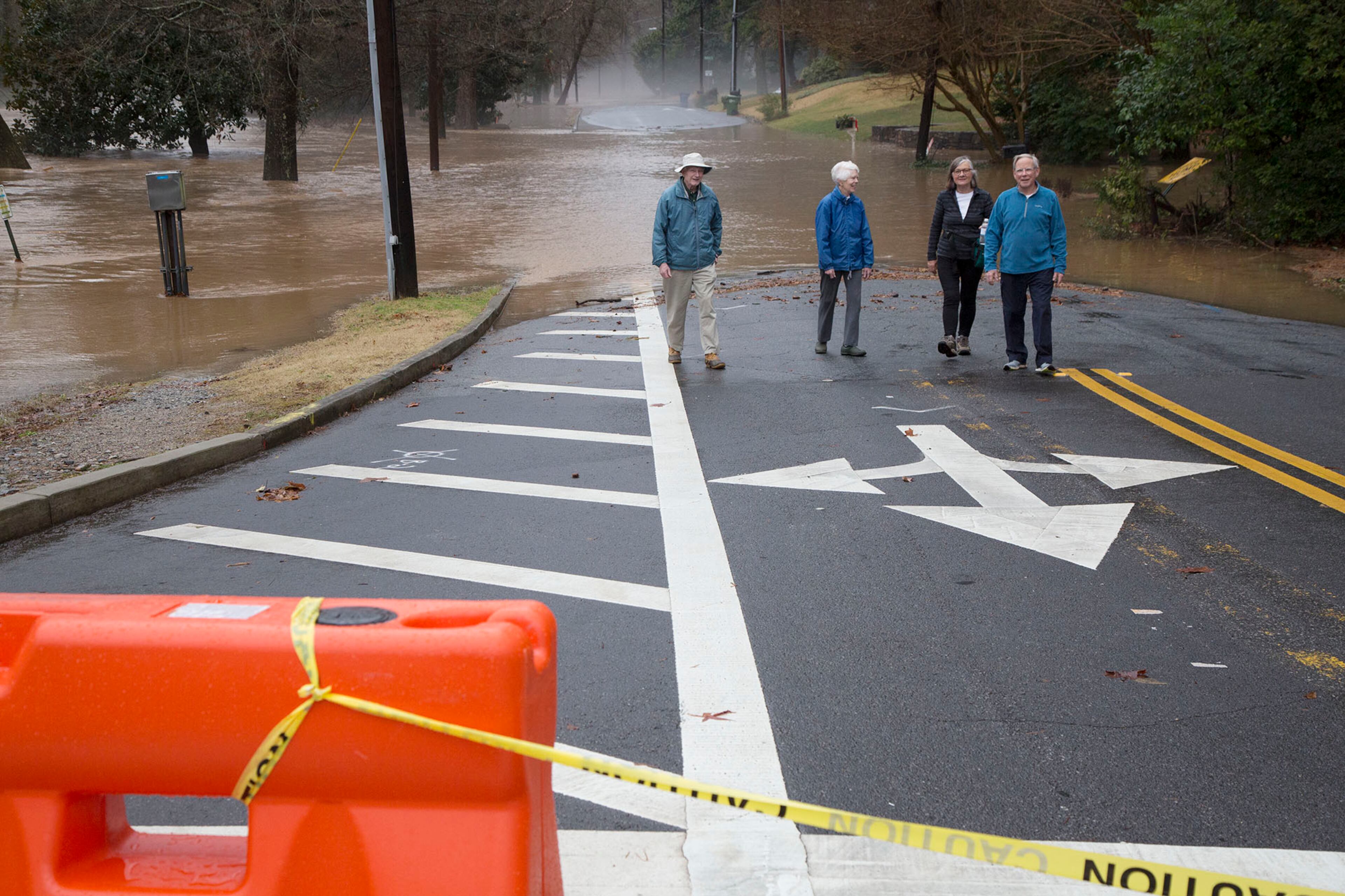 (left to right, all CQ)Neighbors John Whitney, his wife Anne, Angie Meadows & her husband Steve check out the flooding of Peachtree Creek on Woodward Way near Northside Drive on Friday December 28th, 2018. (Photo by Phil Skinner)