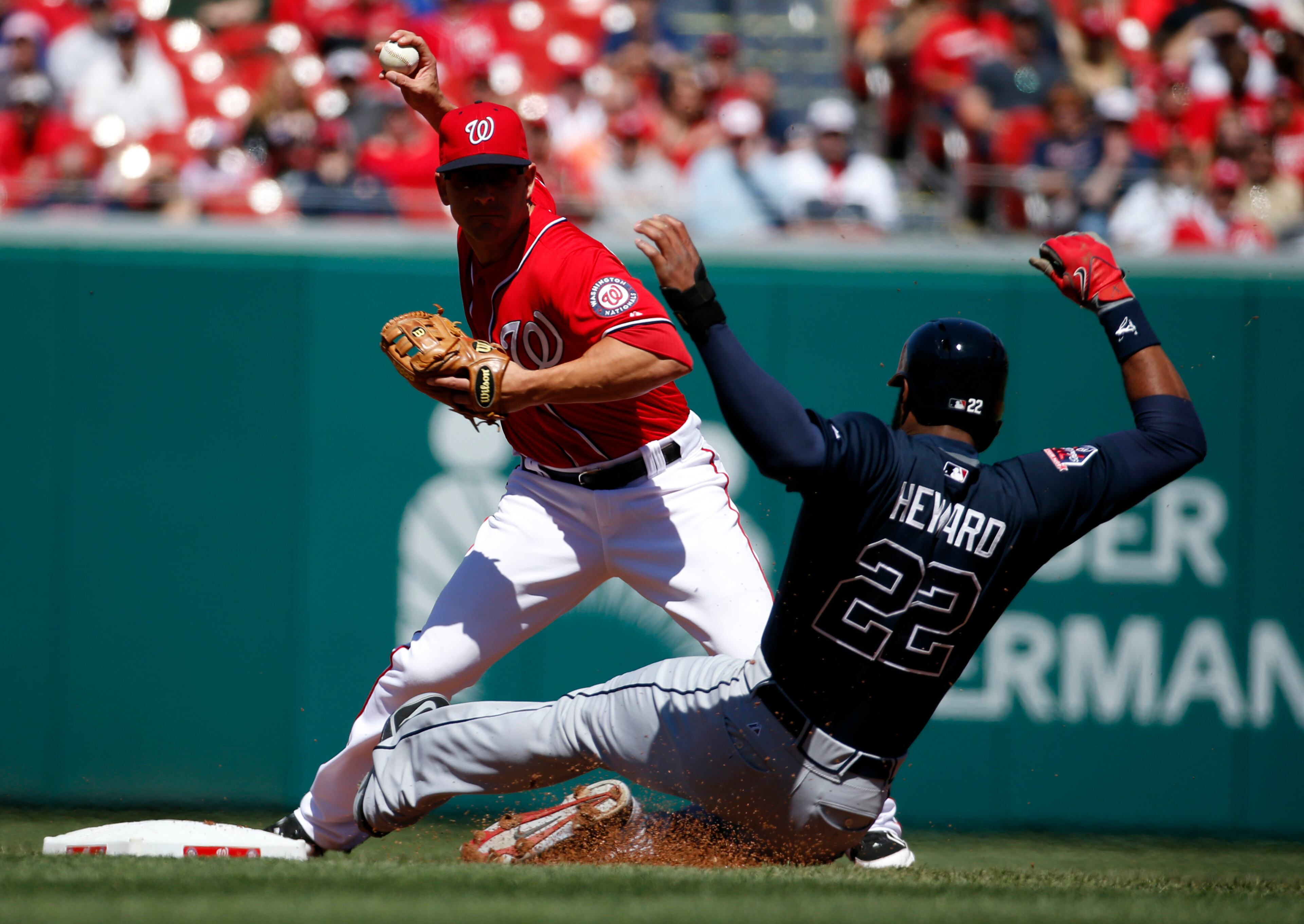 Washington Nationals second baseman Danny Espinosa gets the out against Atlanta Braves' Jason Heyward (22) and throws to first to complete the double play during the first inning of a baseball game at Nationals Park, Sunday, April 6, 2014, in Washington. (AP Photo/Alex Brandon)