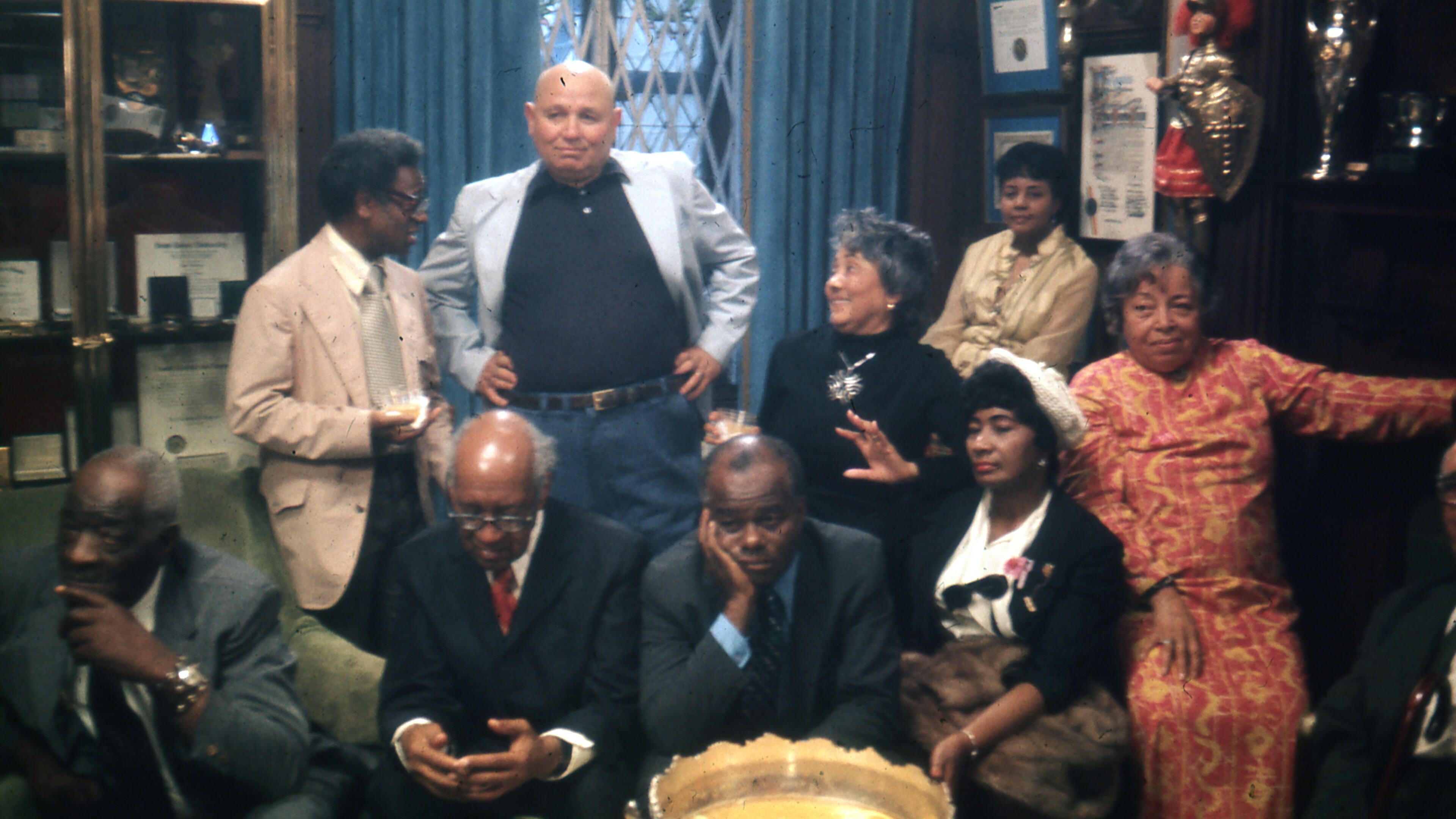 This image released by Neon shows, seated from left, Thomas Harvey, William Patterson, John Henrik Clarke, Mrs. J.B Matthews, and Louise Patterson, standing from left, Ernest Crichlow, Romare Bearden, and Ida Mae Cullen a scene from the documentary "Once Upon a Time in Harlem." (Neon via AP)