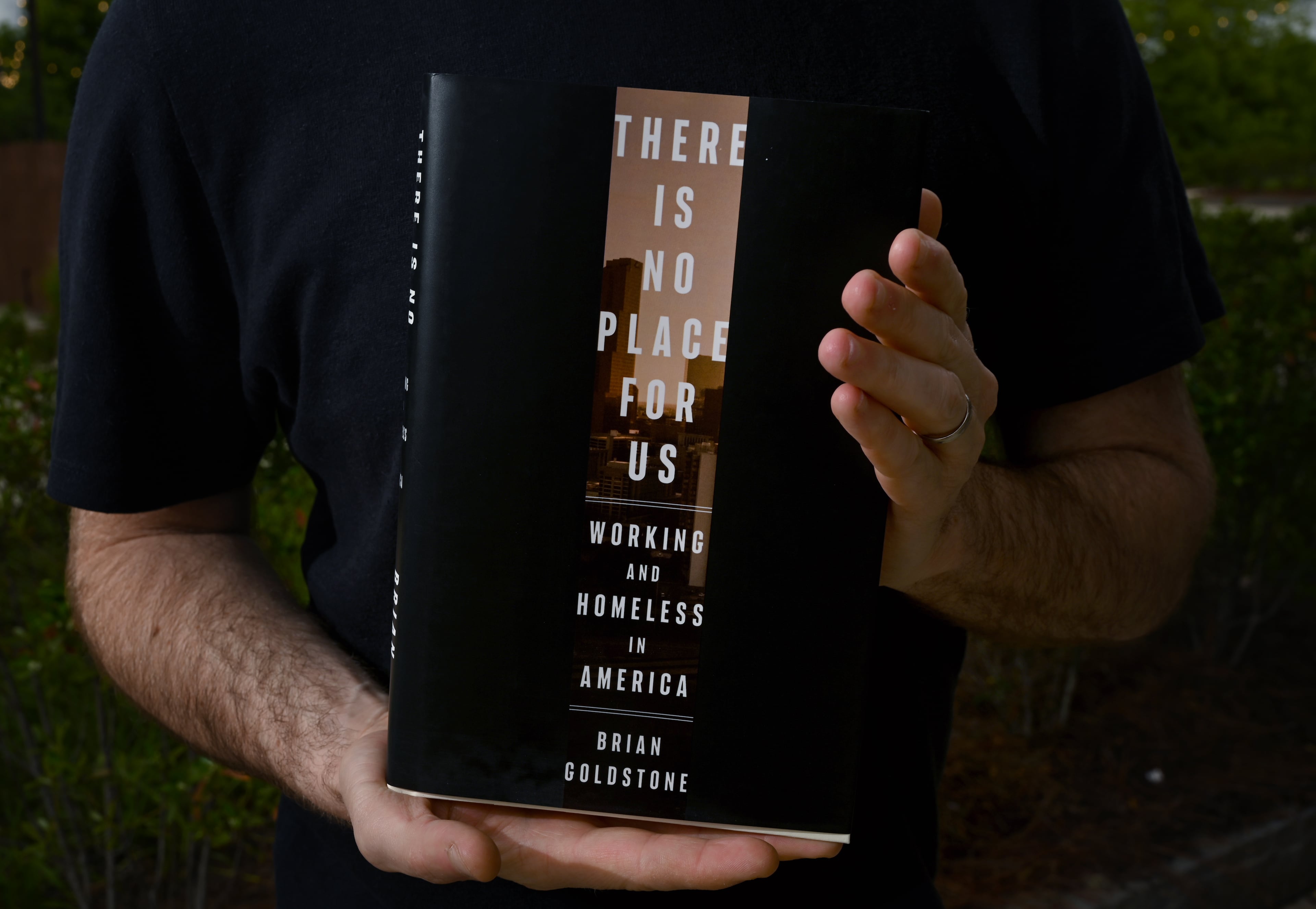 Brian Goldstone holds his Crown Publishing book “There Is No Place For Us,” which details the stories of five Atlanta families who are employed but fighting homelessness because their wages cannot keep up with Atlanta’s unaffordable housing. (Hyosub Shin/AJC)