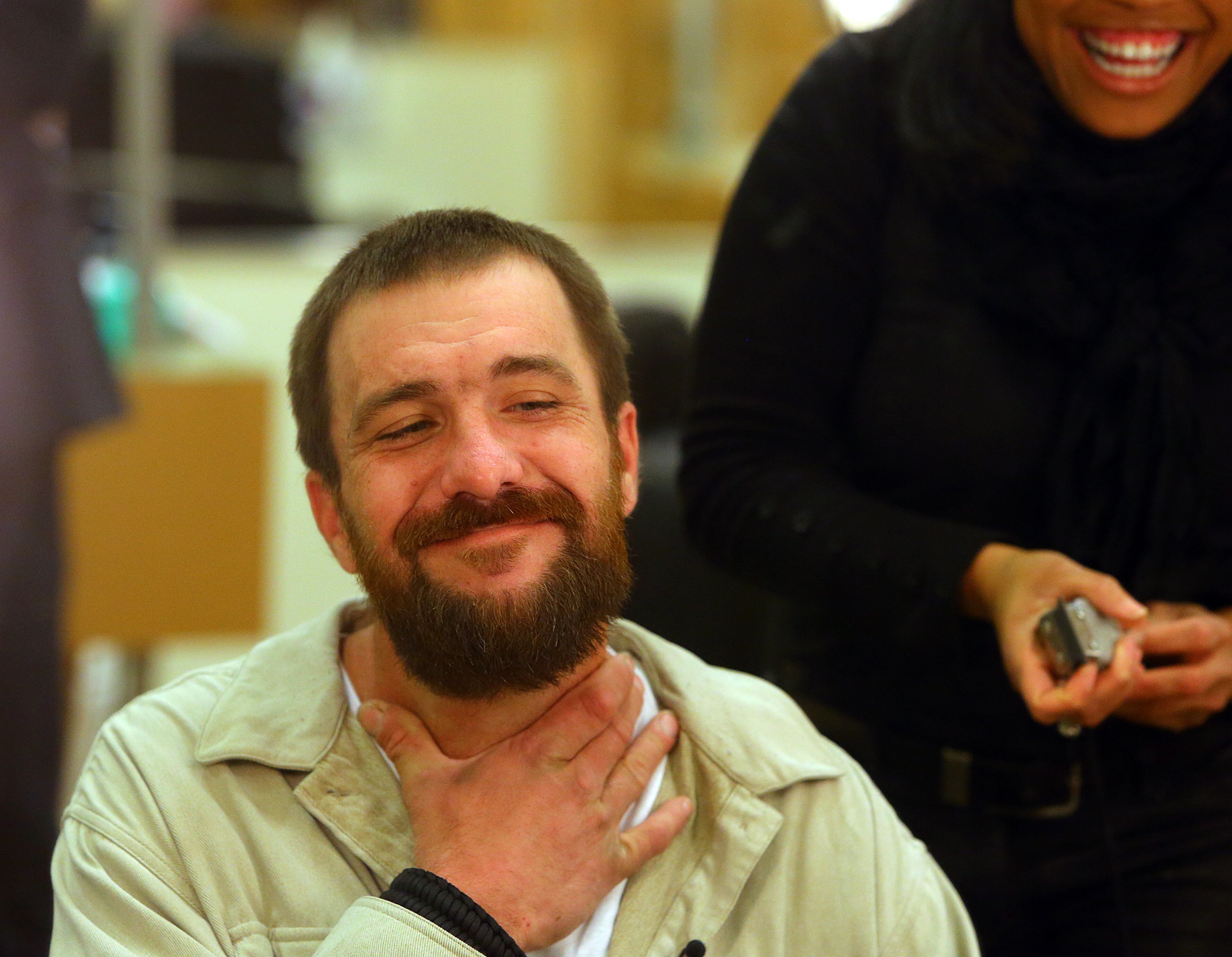 Joel Hartman, the "Homeless Hero," admires his new look at the conclusion of his makeover at Nelda's Hair Salon from hair and makeup artist Nesha Lewis on Nov. 25, 2013, in Atlanta.