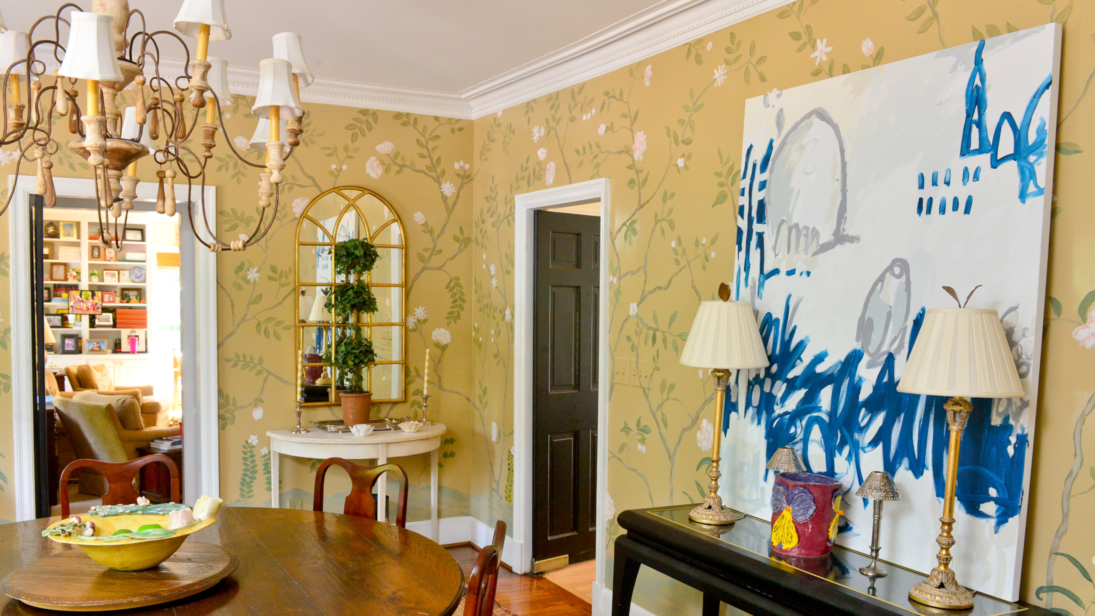 Artist and homeowner Nancy B. Westfall painted her dining room walls by drawing the chinoiserie-inspired floral design in chalk. "I left it in chalk for two years," she said. "Then people would bump into it and get it erased. I had to finally make it permanent." Artwork and a vase made by people with special needs from Creative Growth Art Center in Oakland, Calif., introduce more color into the room.