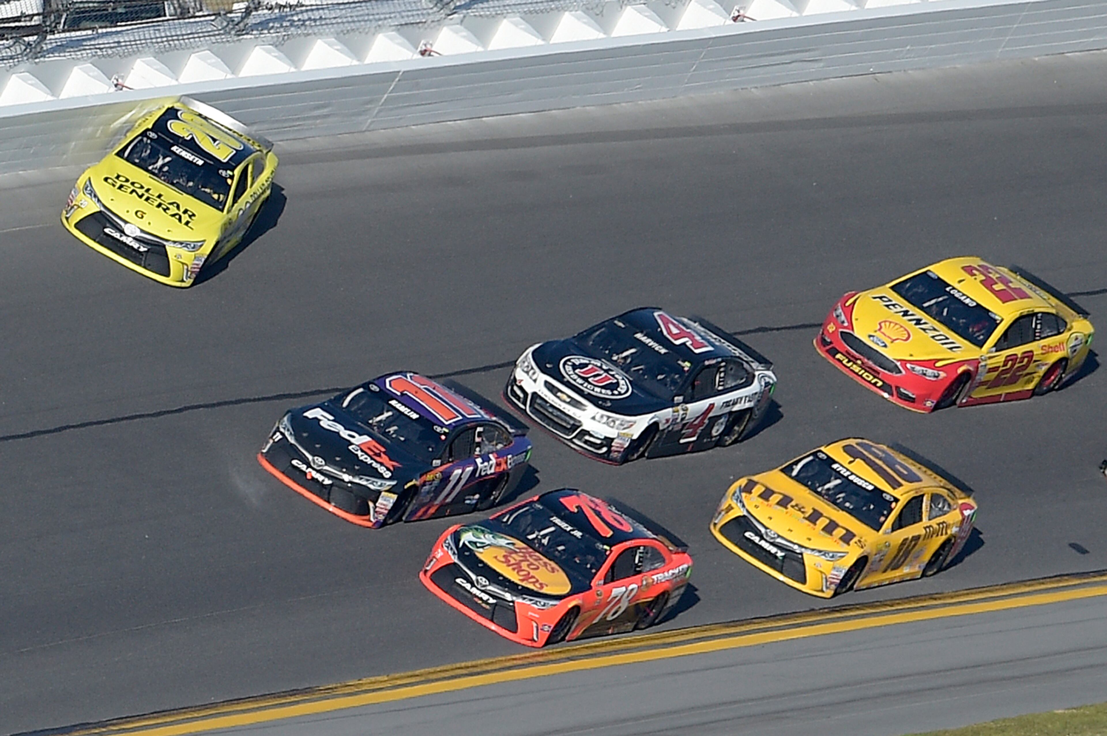 Denny Hamlin (11) and Martin Truex Jr. (78) take the lead from Matt Kenseth (20) in Turn 4 on the final lap during the NASCAR Daytona 500 Sprint Cup series auto race at Daytona International Speedway, Sunday, Feb. 21, 2016, in Daytona Beach, Fla. (AP Photo/Phelan M. Ebenhack)