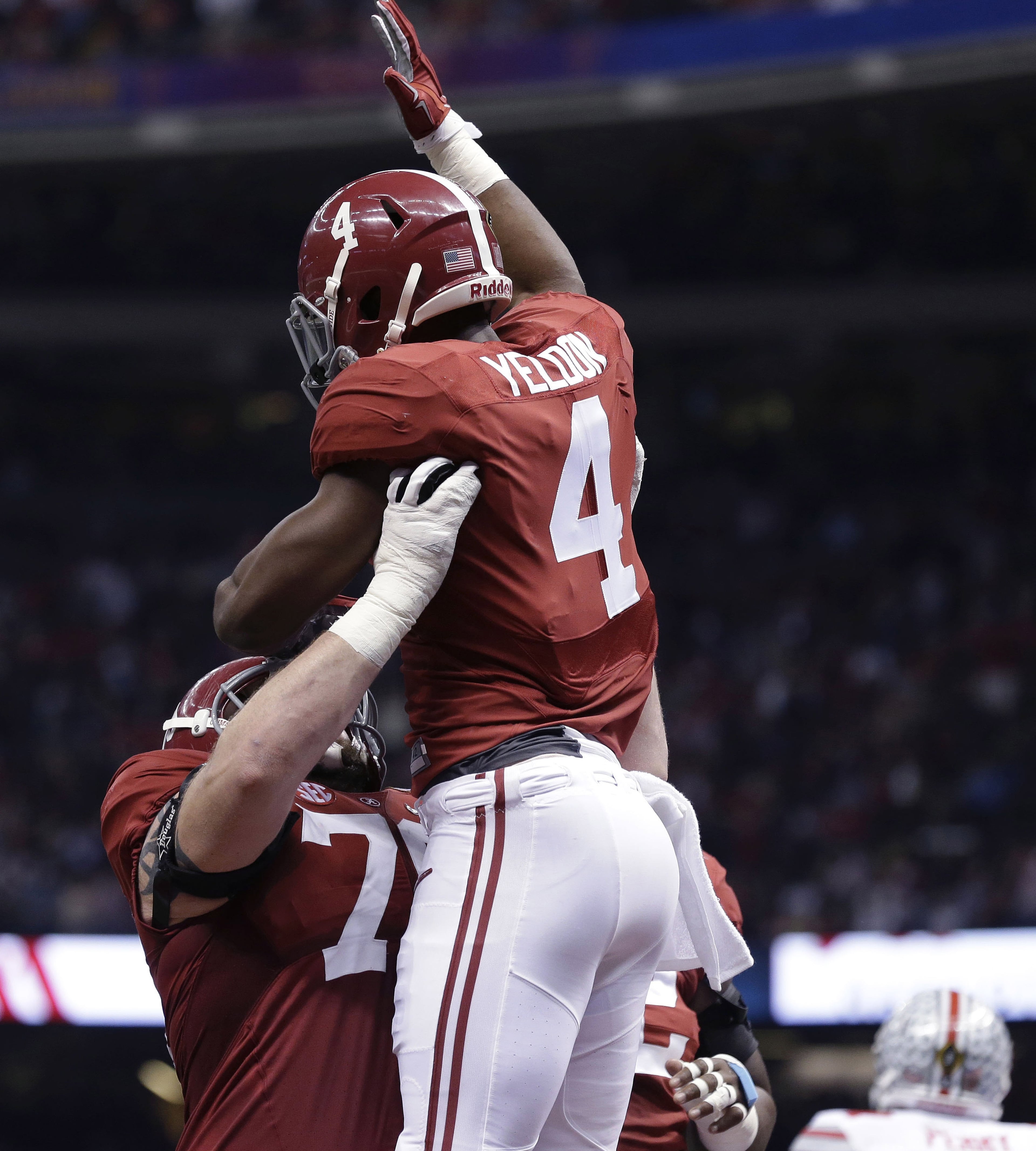 Alabama offensive lineman Cam Robinson (74) lifts Alabama running back T.J. Yeldon (4) after Yeldon's touchdown against Ohio State in the first half of the Sugar Bowl NCAA college football playoff semifinal game, Thursday, Jan. 1, 2015, in New Orleans. (AP Photo/Brynn Anderson)