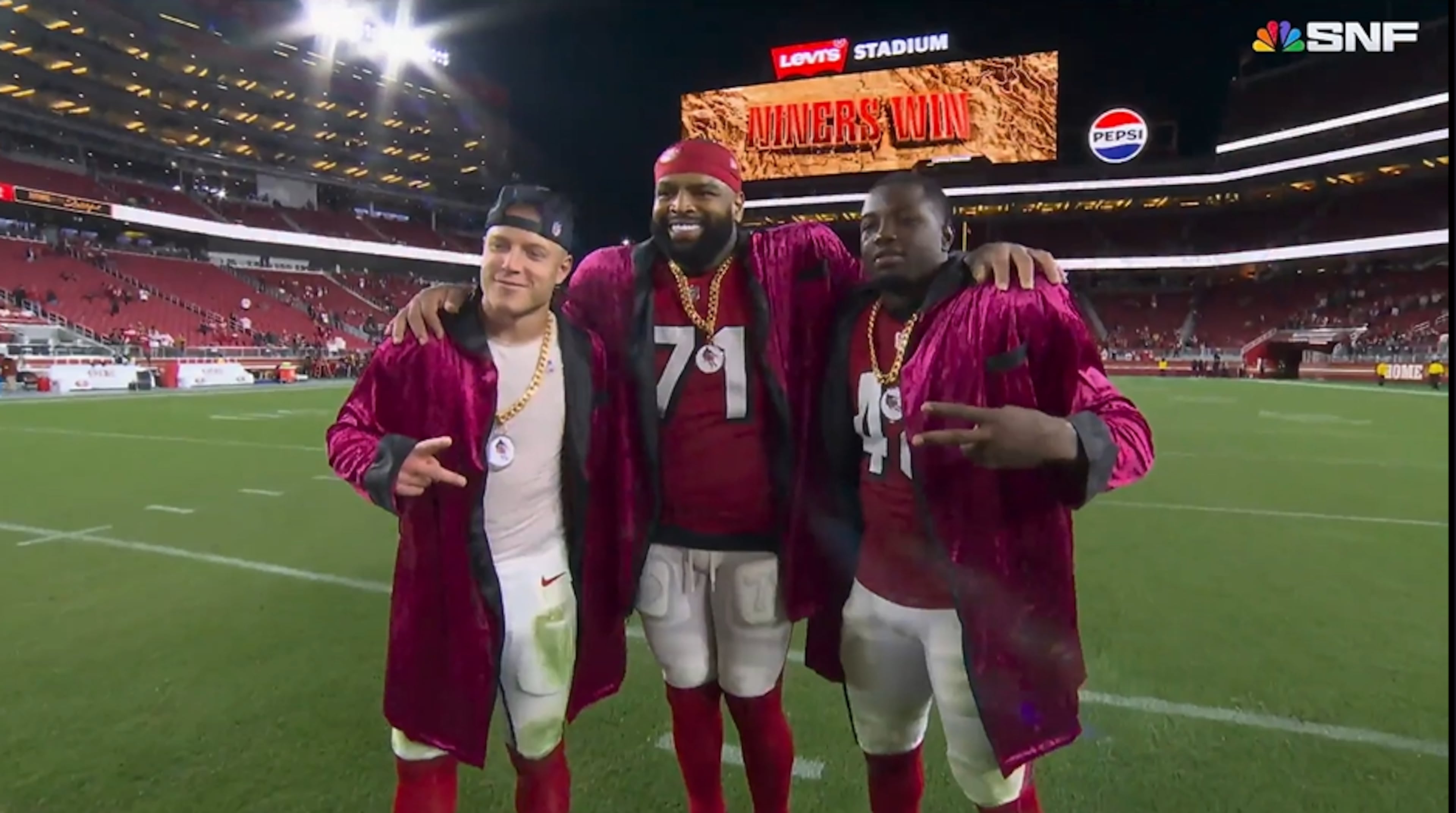 San Francisco 49ers running back Christian McCaffrey (left), offensive tackle Trent Williams (middle) and linebacker Tatum Bethune pose for a picture in their robes Oct. 19, 2025, after defeating the Falcons in the first edition of "National Running Backs Day." (Courtesy of NBC Sports)