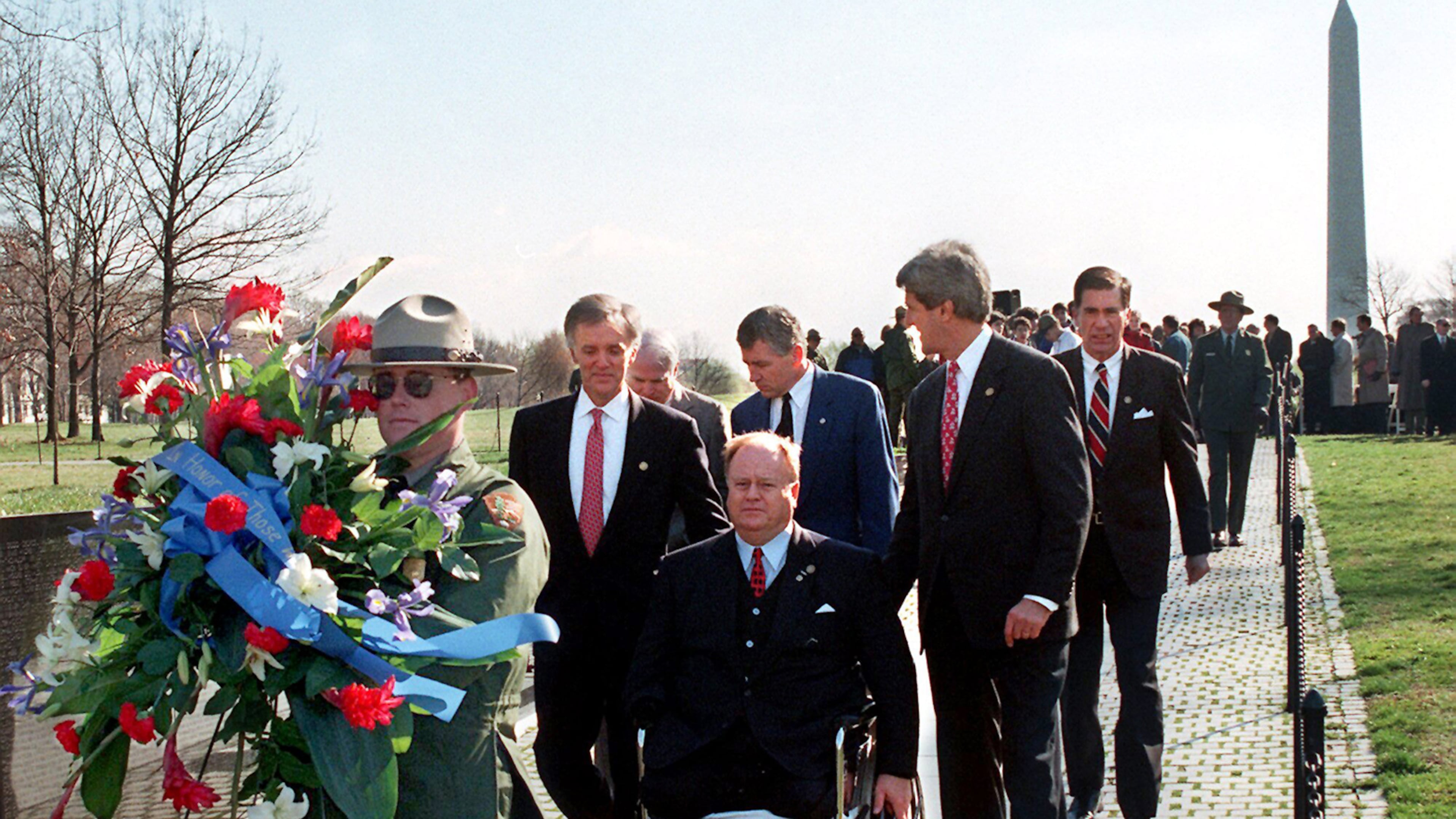 In this photo from 1997, then-U.S. Sen. Max Cleland, D-Ga. (in wheelchair), and fellow senators (left to right) Bob Kerrey, D-Neb.; John McCain, R-Ariz.; Charles Hagel, R-Neb.; John Kerry, D-Mass.; and Chuck Robb, D-Va. walk along the Vietnam Veterans Memorial wall behind the wreath they would lay to commemorate the 15th anniversary of groundbreaking for the memorial. All six senators served in Vietnam, and Cleland lost both legs and an arm in that war. (Rick McKay/Washington Bureau)