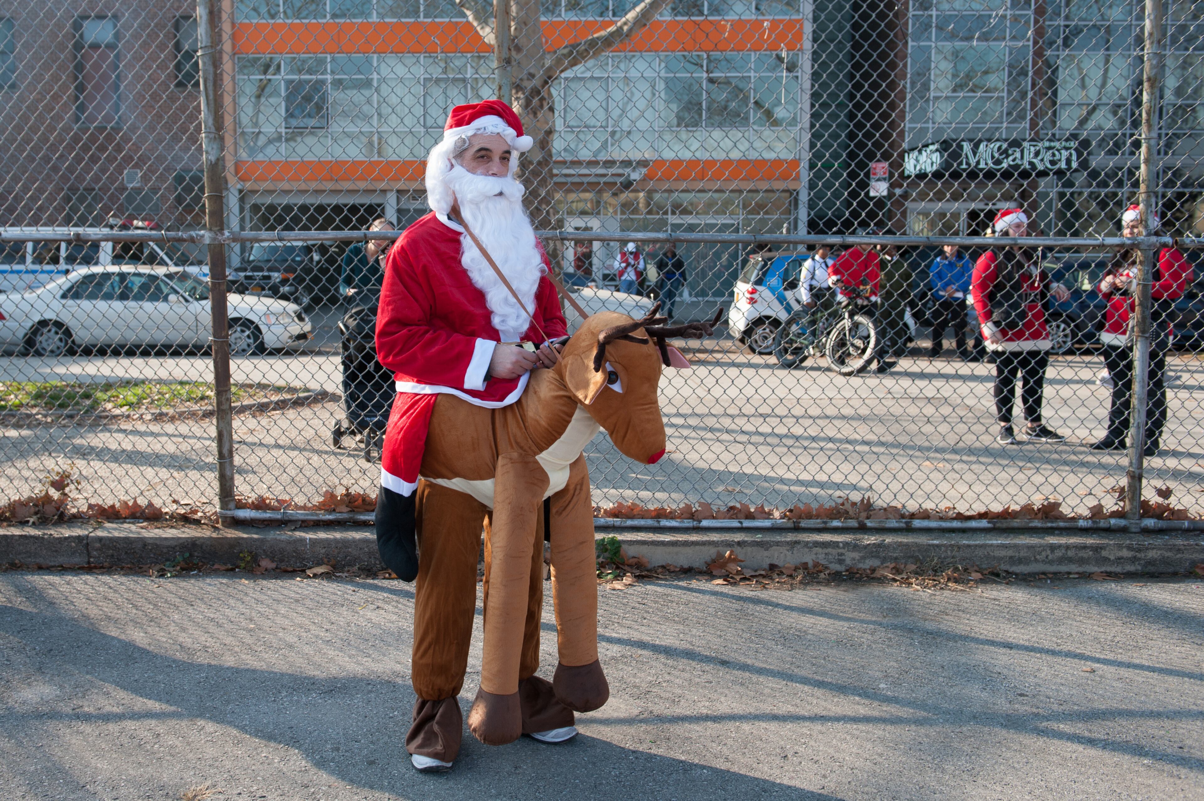 NEW YORK, NY - DECEMBER 12: A man dressed as a Santa with his reindeer waits for the start of the annual SantaCon pub crawl December 12, 2015 in the Brooklyn borough of New York City. Hundreds of revelers take part in the holiday pub crawl, though some local bars and businesses have banned participants in an effort to avoid the typically rowdy SantaCon crowds. (Photo by Stephanie Keith/Getty Images)