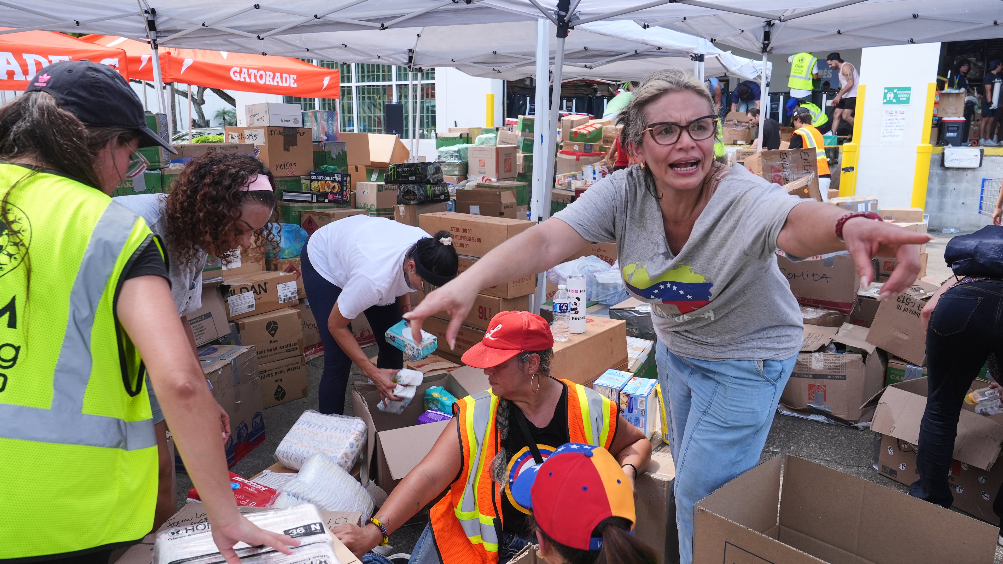 Lisa Galindez calls on other volunteers to help pack baby items at the Global Empowerment Mission Venezuela relief donation site Tuesday, June 30, 2026, in Doral, Fla. (AP Photo/Marta Lavandier)