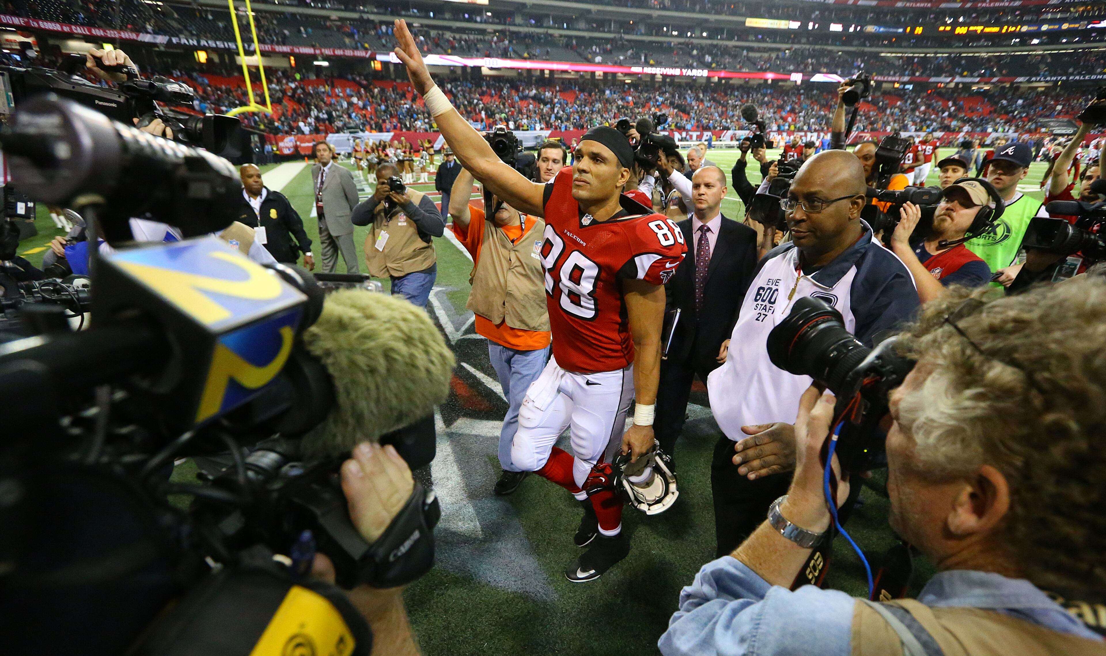 Falcons tight end Tony Gonzalez is surrounded by media as he waves farewell to fans walking off the field after playing his final NFL football game against the Panthers on Sunday, Dec. 29, 2013, in Atlanta.