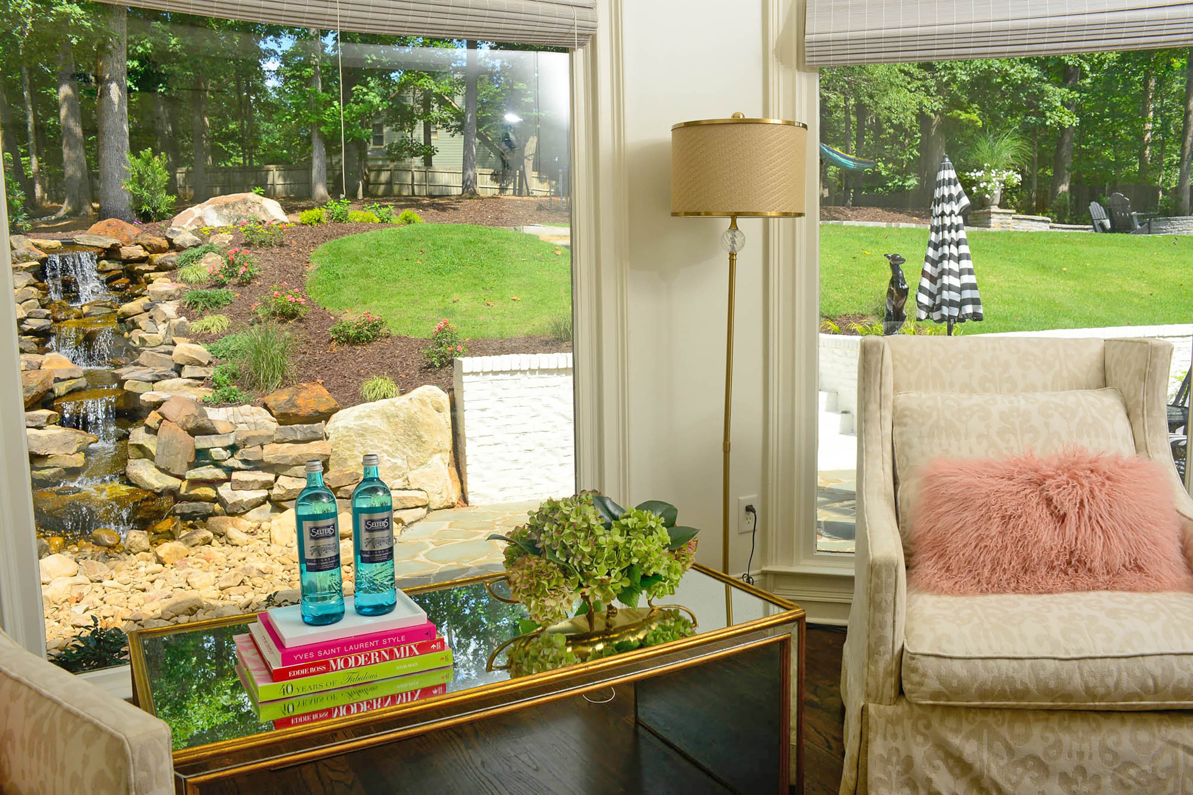 “Art and design are in my blood,” said homeowner Jill Edee, who learned from her mother, Pamela C. Renfroe, a licensed Coca-Cola artist. Swivel chairs frame windows that look out into the backyard. Links Landscaping added a pondless waterfall, slate walkway and firepit. Photo captions by Lori Johnston and Shannon Dominy/Fast Copy News Service.