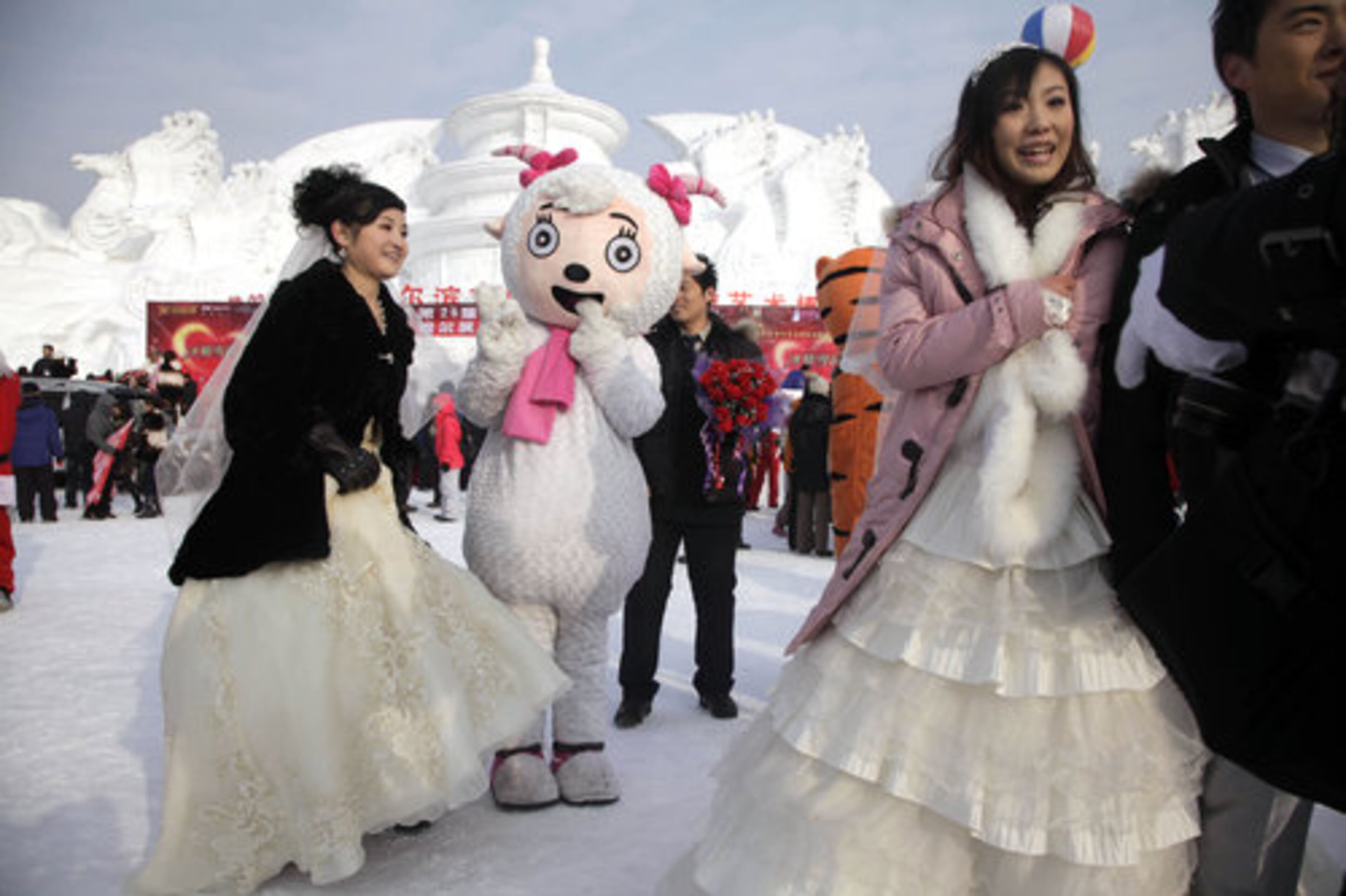 Participants of a group wedding ceremony pose with 'Mei Yangyang' a popular cartoon character in Harbin in northeastern China's Heilongjiang province.