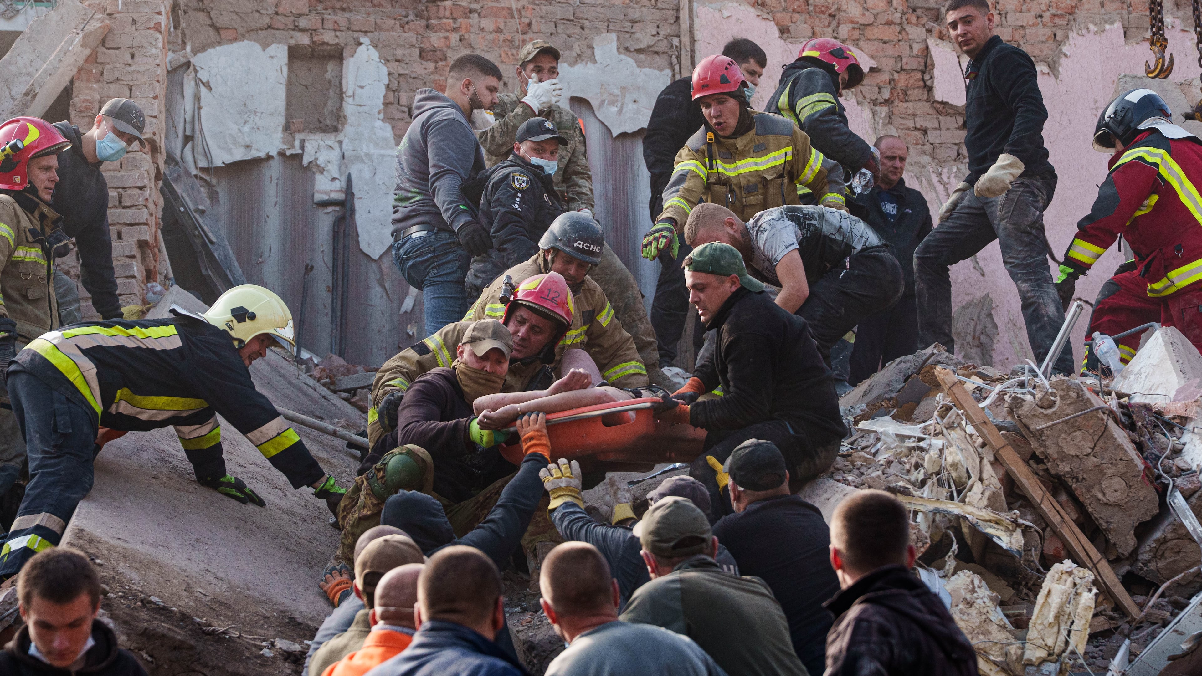 Locals and rescuers carry out an injured man from a residential building destroyed in a Russian missile strike on Pryluky, Ukraine, Wednesday, Oct. 7, 2026. (AP Photo/Evgeniy Maloletka)