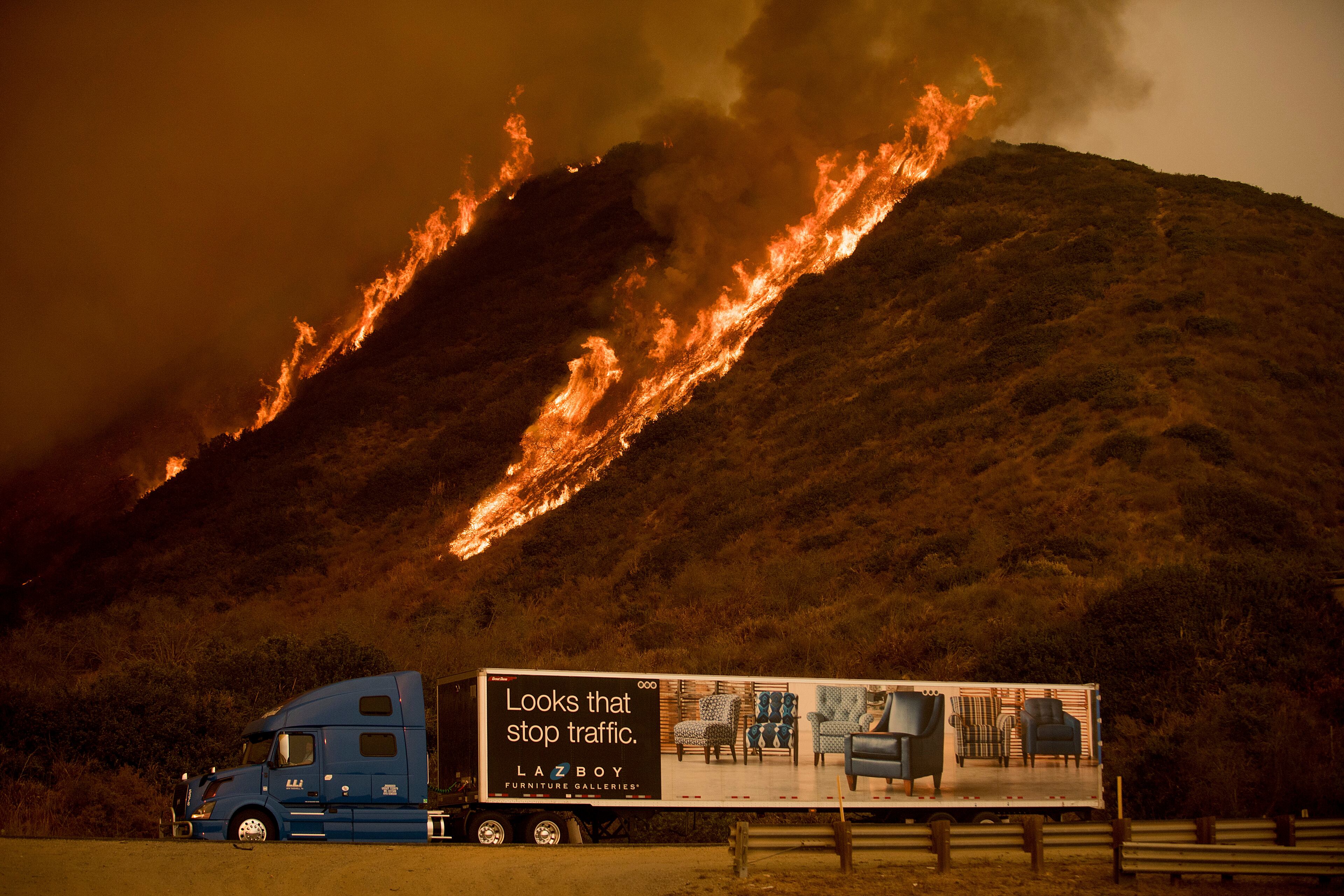 Motorists on Highway 101 watch flames from the Thomas fire leap above the roadway north of Ventura, Calif., on Wednesday, Dec. 6, 2017. As many as five fires have closed highways, schools and museums, shut down production of TV series and cast a hazardous haze over the region. About 200,000 people were under evacuation orders. No deaths and only a few injuries were reported.