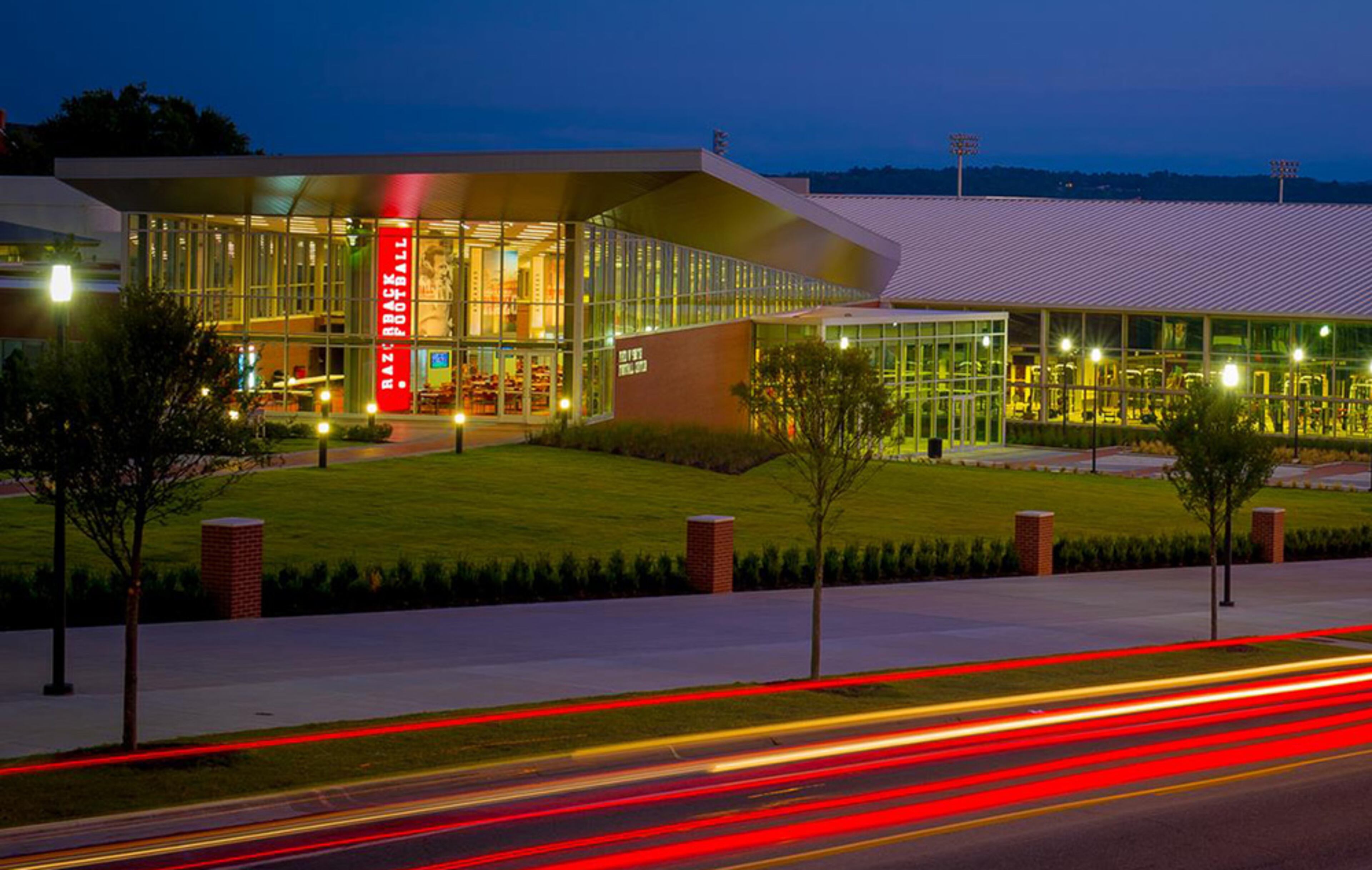 The 80,000 square-foot Fred W. Smith Football Center includes a spacious locker room, team meeting rooms, training room, equipment room, a student-athlete lounge and study area, coaches’ offices, a recruiting reception area and football displays celebrating the tradition of Razorback Football. In the fall of 2012 as part of the football center project, two new practice fields and a parking deck were completed south of the Walker Family Training Center providing the football team with spectacular new practice venues and university faculty and students with approximately 225 covered parking spaces.