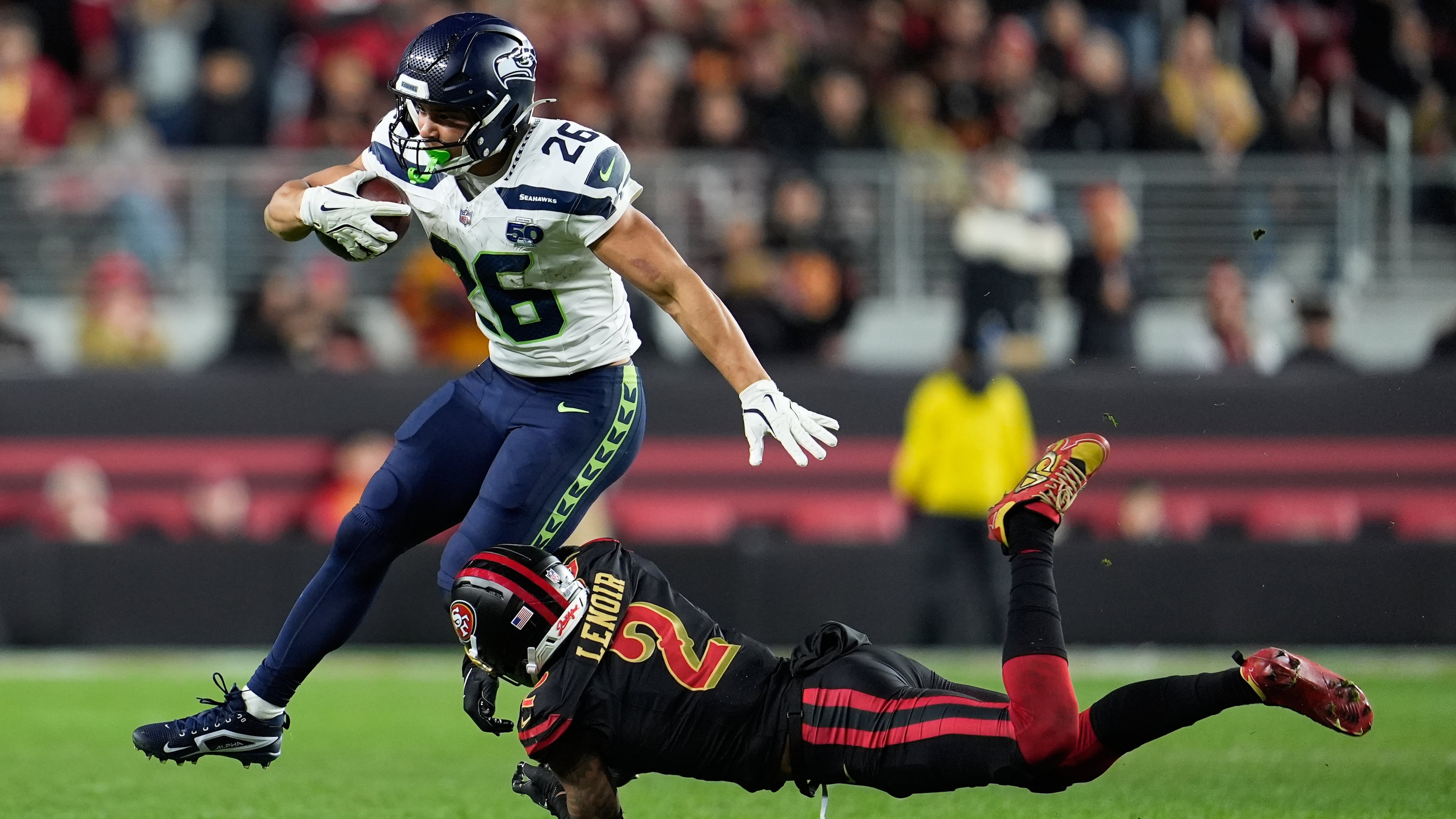 Seattle Seahawks running back Zach Charbonnet (26) runs against San Francisco 49ers cornerback Deommodore Lenoir (2) during the second half of an NFL football game in Santa Clara, Calif., Saturday, Jan. 3, 2026. (AP Photo/Godofredo A. Vásquez)