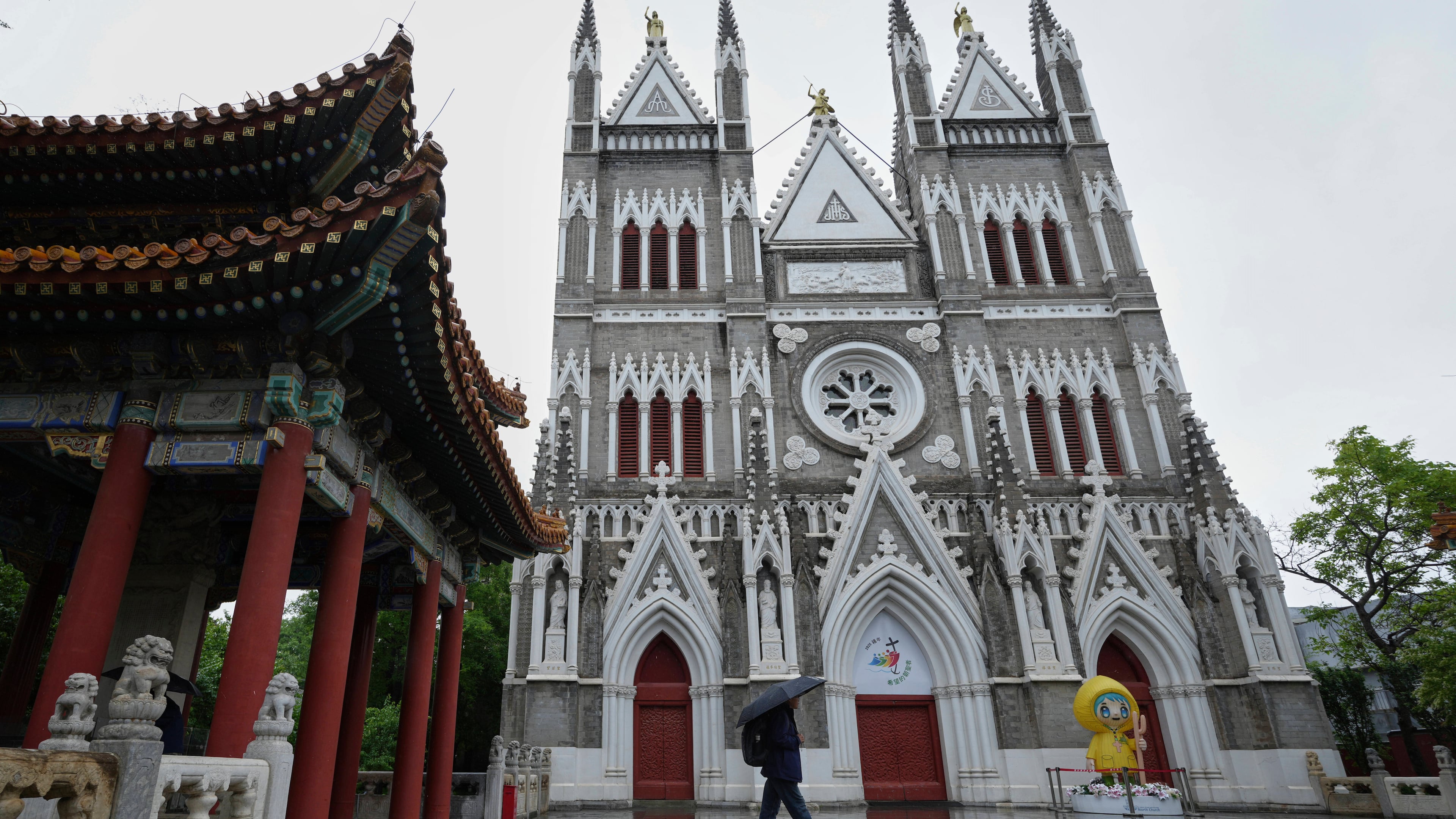FILE - A man walks out from a pavilion near the Xishiku Catholic Church during a rainy day in Beijing, May 9, 2025. (AP Photo/Andy Wong, File)