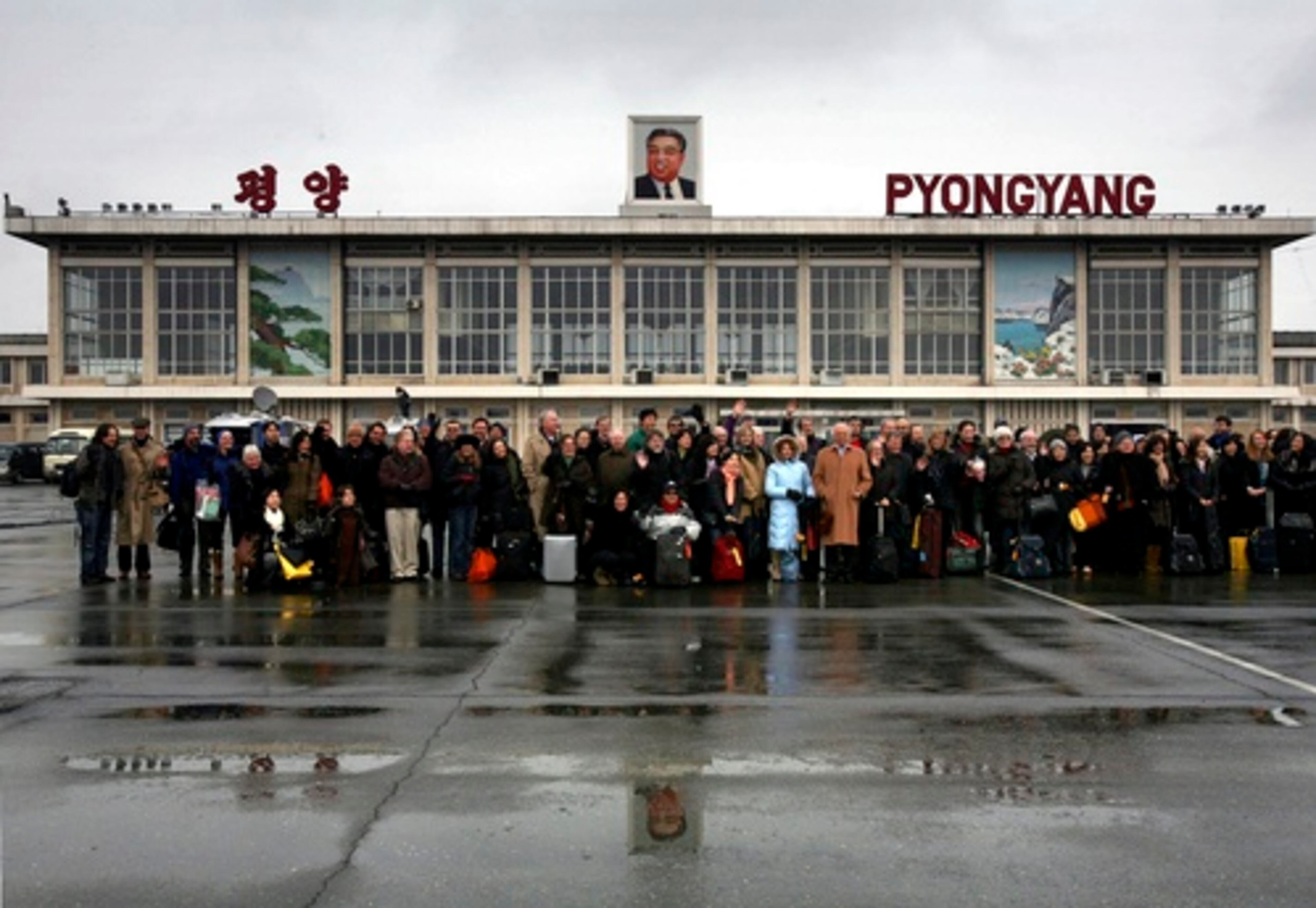 The New York Philharmonic pose for photos at the airport.