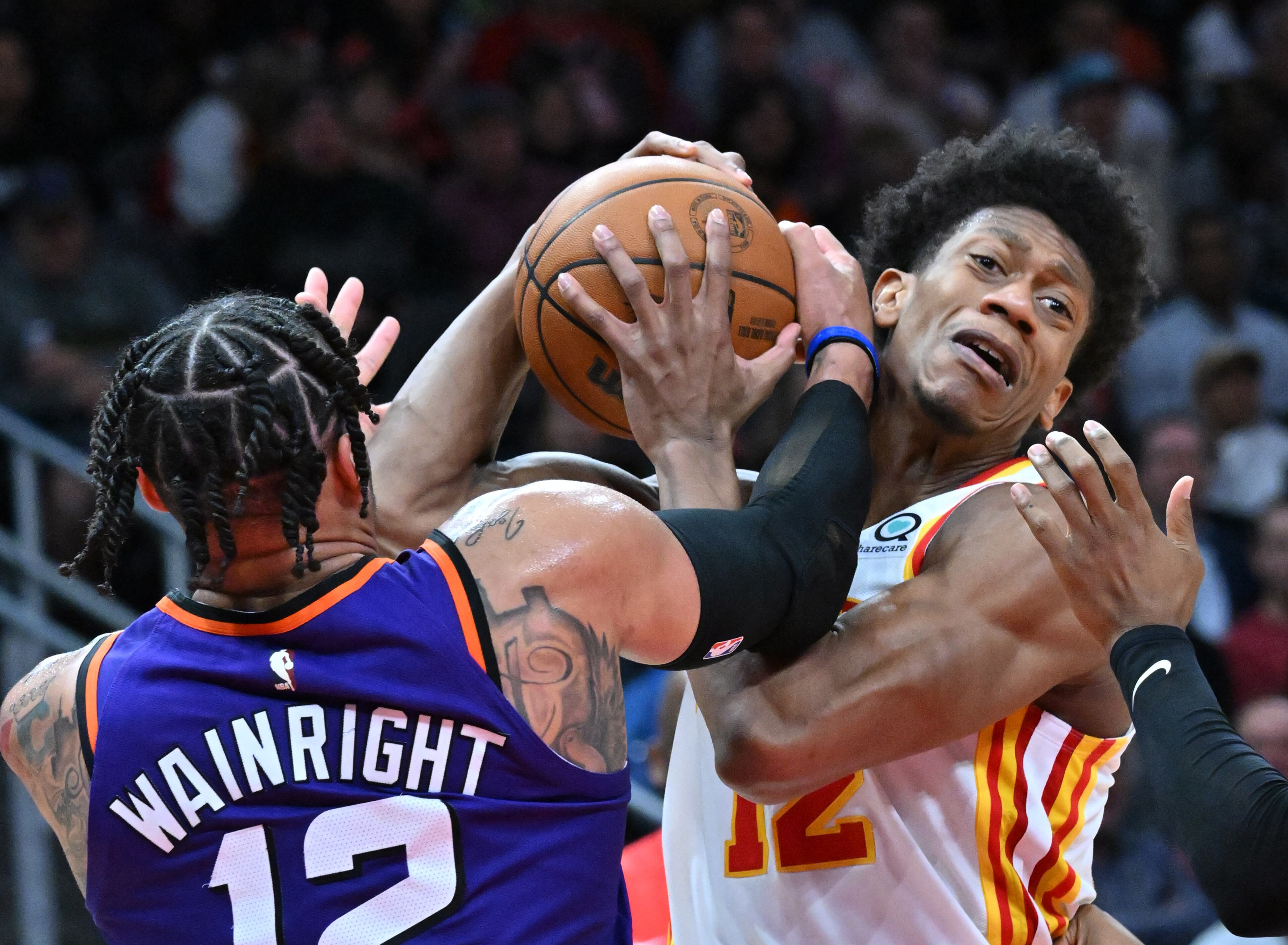 Phoenix Suns' forward Ish Wainright (left) and Atlanta Hawks' forward De'Andre Hunter (right) fight for a ball. (Hyosub Shin / Hyosub.Shin@ajc.com)