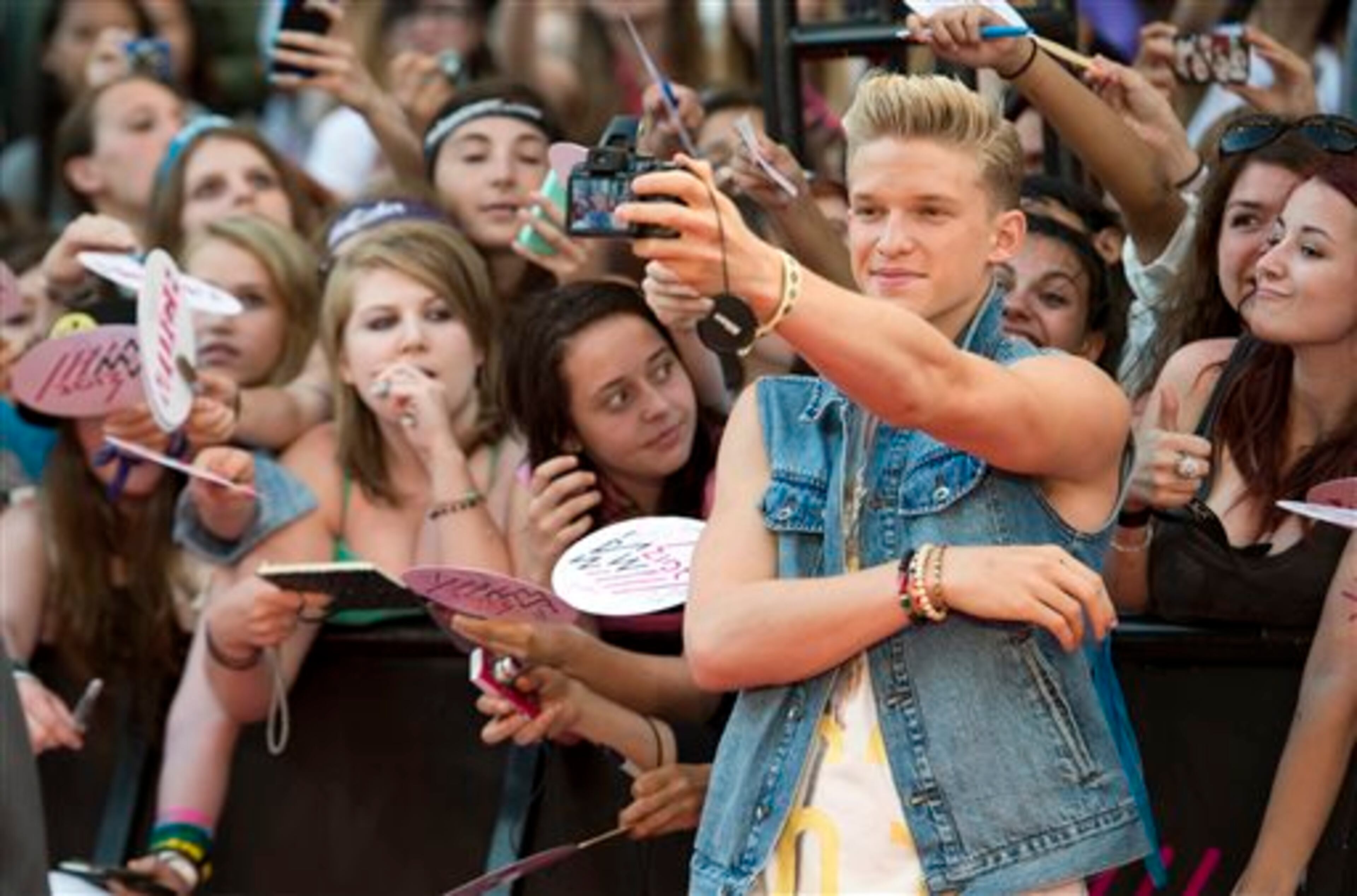 Cody Simpson takes a photo with fans on the red carpet during the 2013 MuchMusic Video Awards in Toronto on Sunday, June 16, 2013. (AP Photo/The Canadian Press, Nathan Denette)