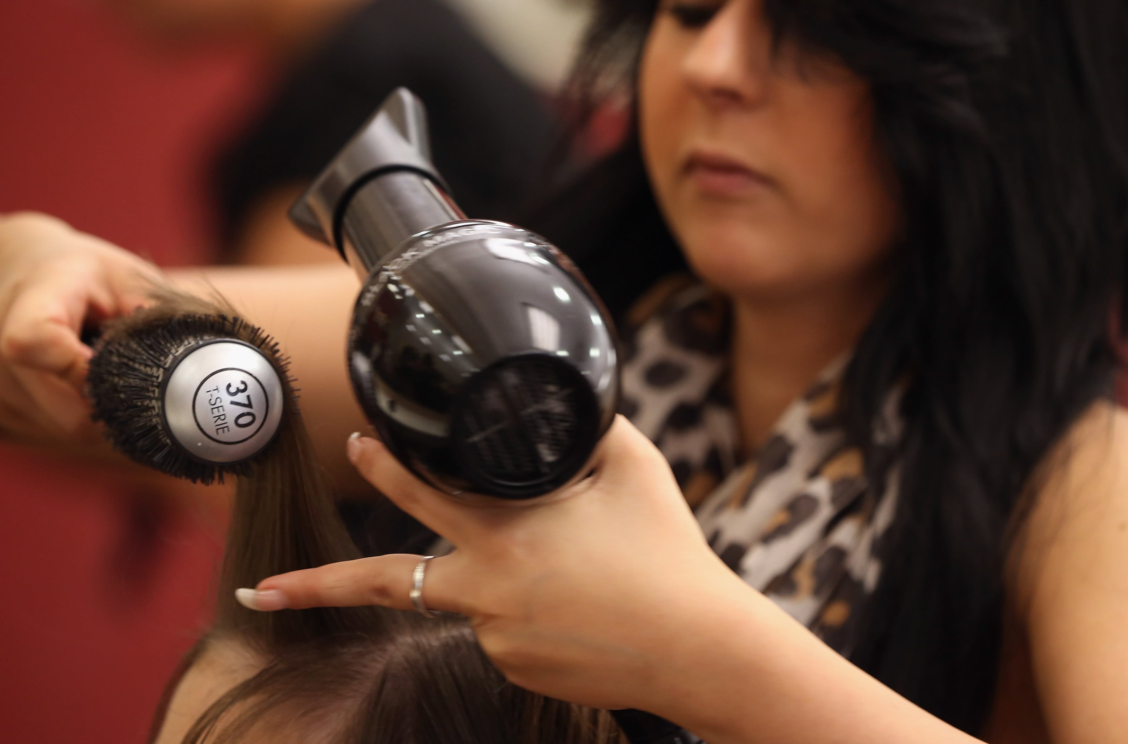 BERLIN, GERMANY - MAY 17: Full-time hair stylist Sabina tends to a customer at the Cut and Color Friseur Klier hair salon in the Alexa shopping mall on May 17, 2013 in Berlin, Germany. Klier, a German, nationwide chain of hair salons, has taken the initiative in the current minimum wage debates by already introducing in 12 of its salons in eastern Germany the minimum wage that is to be implemented by new federal legislation. Klier has raised wages in the salons by 30% and also raised prices in an expirement to guage customer willingness to pay more. Germany is to implement a minimum wage of EUR 8.50 an hour for hair stylists and barbers nationwide by 2015. (Photo by Sean Gallup/Getty Images)