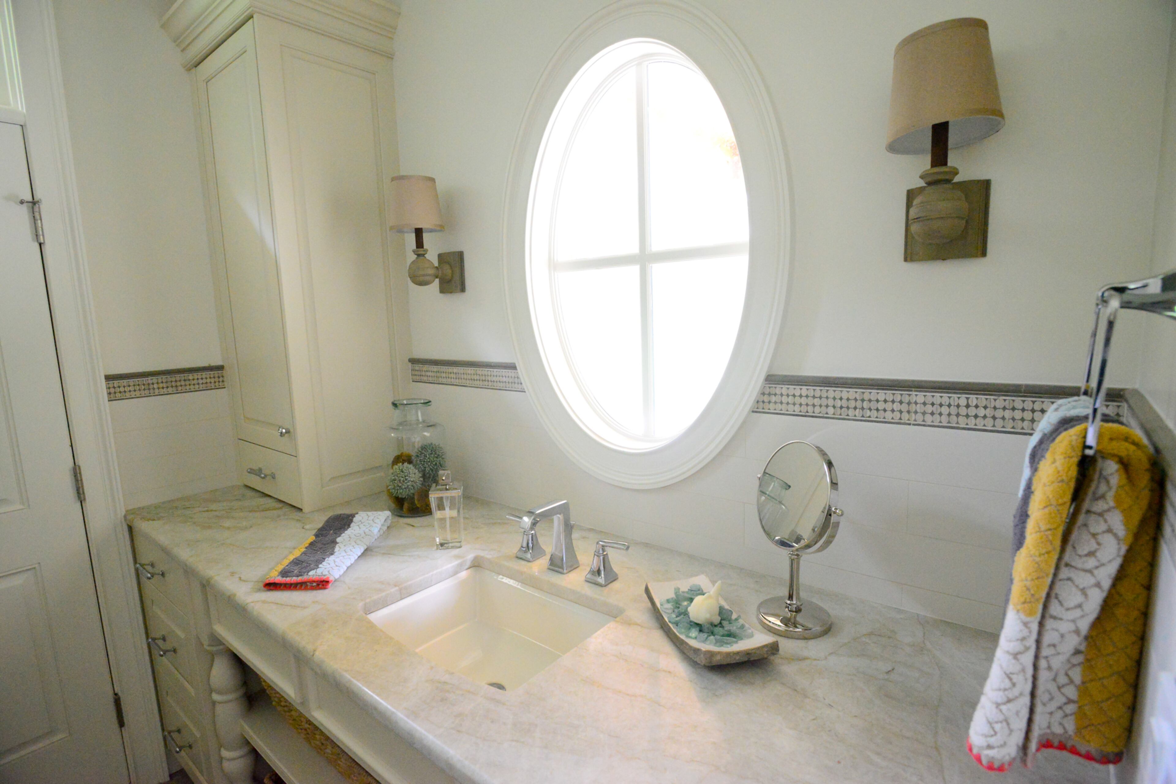 In addition to the shower, the pool room has an upstairs workout space. Oval and arch-shaped windows in the pool house emphasize the connection to the outdoors. -- Text by Lori Johnston