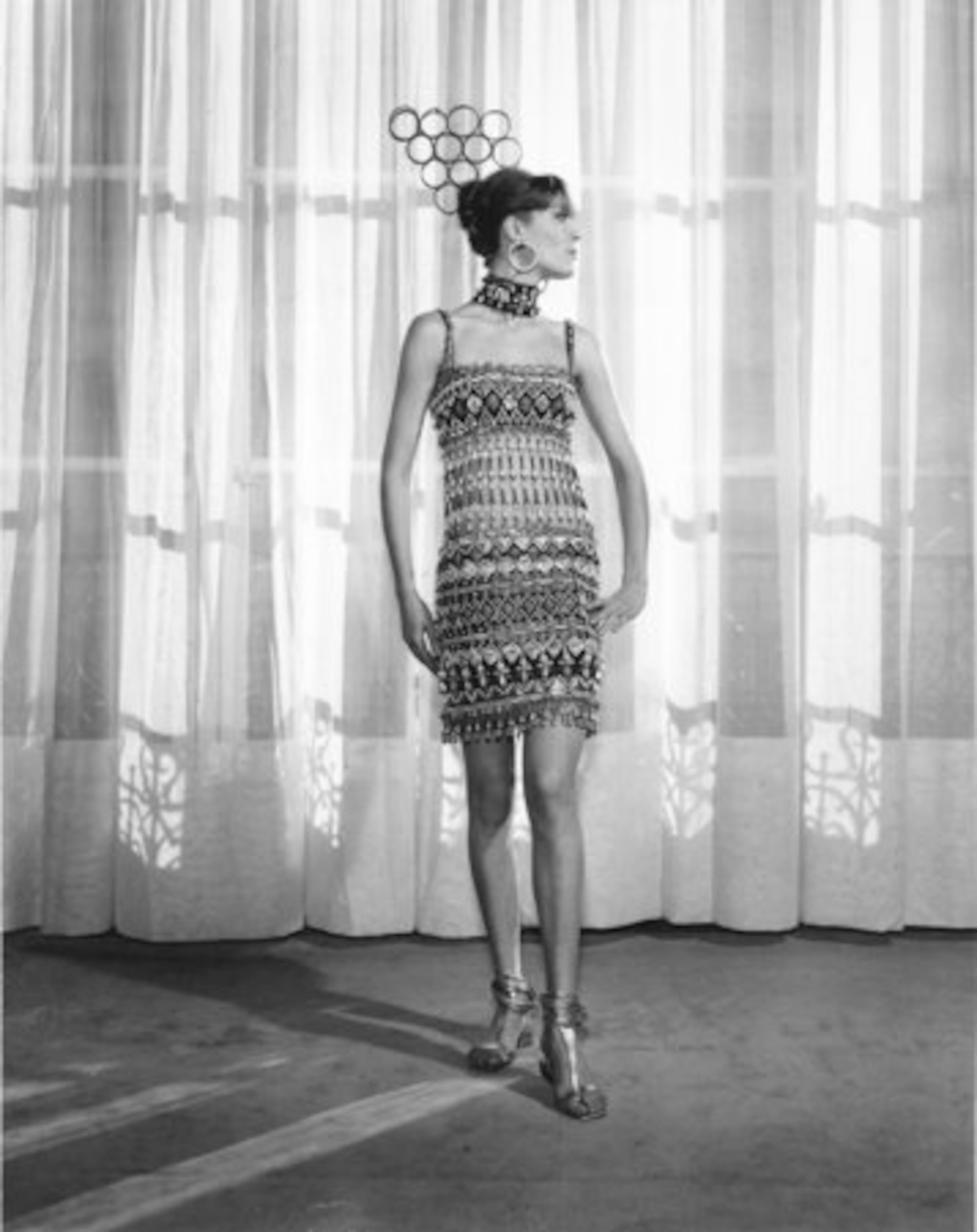 A model wears an African style dress embroidered with wooden beads, pearls and sequins of turquoise, pink and black, created by Yves Saint Laurent