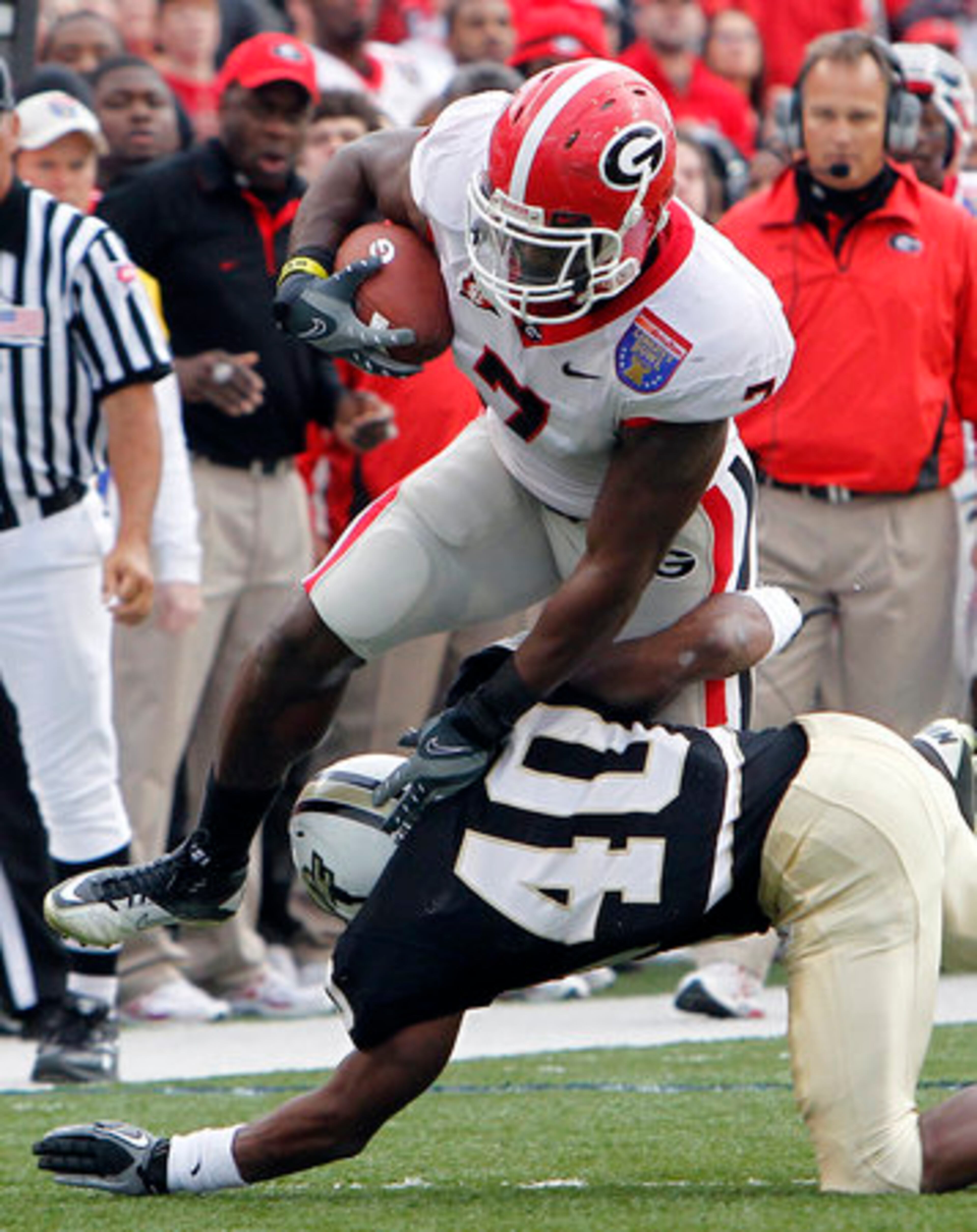 Georgia tight end Orson Charles (7) tries to get past Central Florida defensive back Reggie Weams (40) in the first quarter of the Liberty Bowl NCAA college football game Friday, Dec. 31, 2010, in Memphis, Tenn.