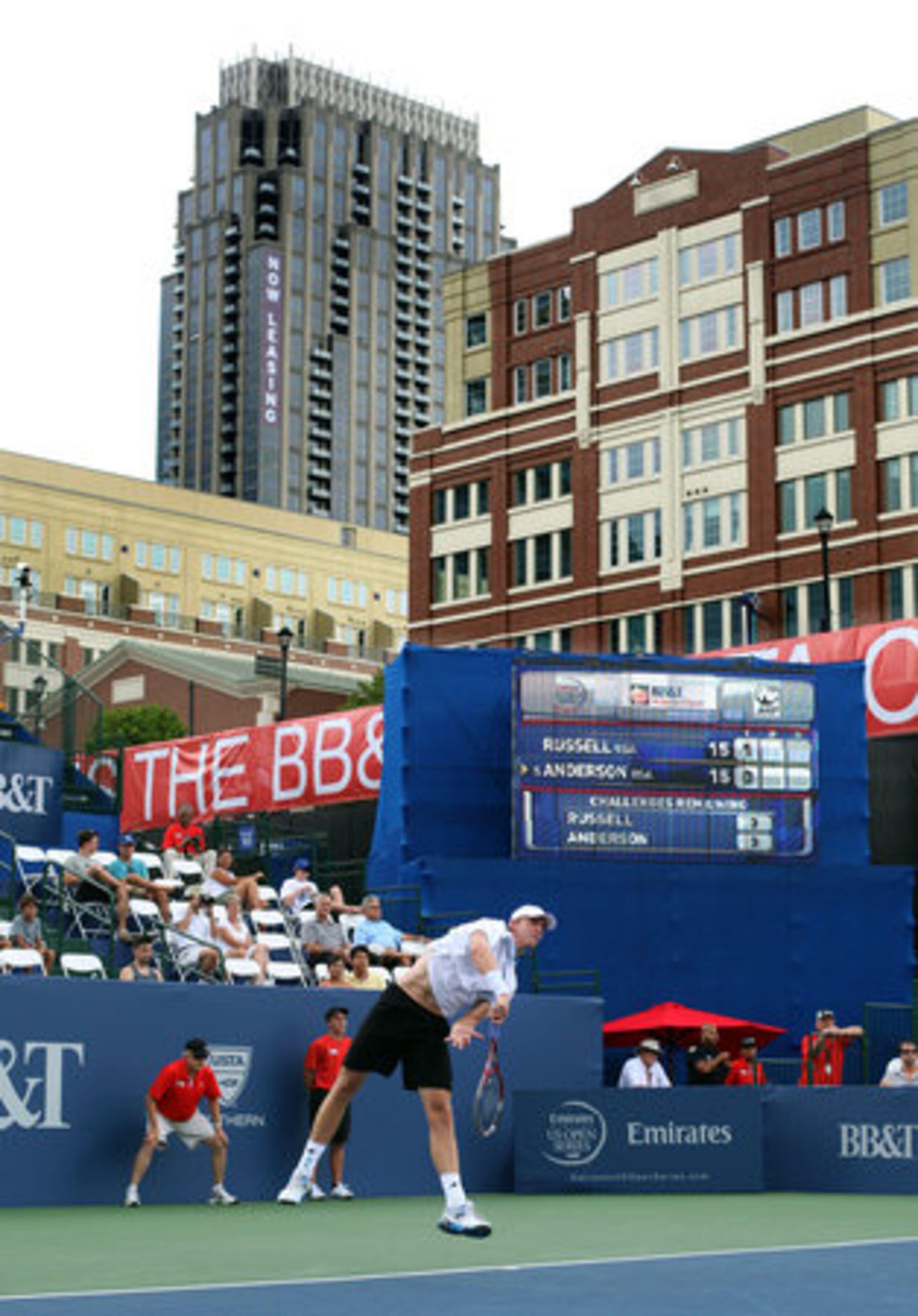 Under the buildings of Atlantic Station, Kevin Anderson, of South Africa, follows through on a serve to Michael Russell, of USA, during their second round match on stadium court of the Atlanta Open at Atlantic Station Wednesday afternoon in Atlanta, Ga., July 18, 2012. Stadium court of the Atlanta Open has a unique city feel with tall buildings all around including the Atlanta skyline.
