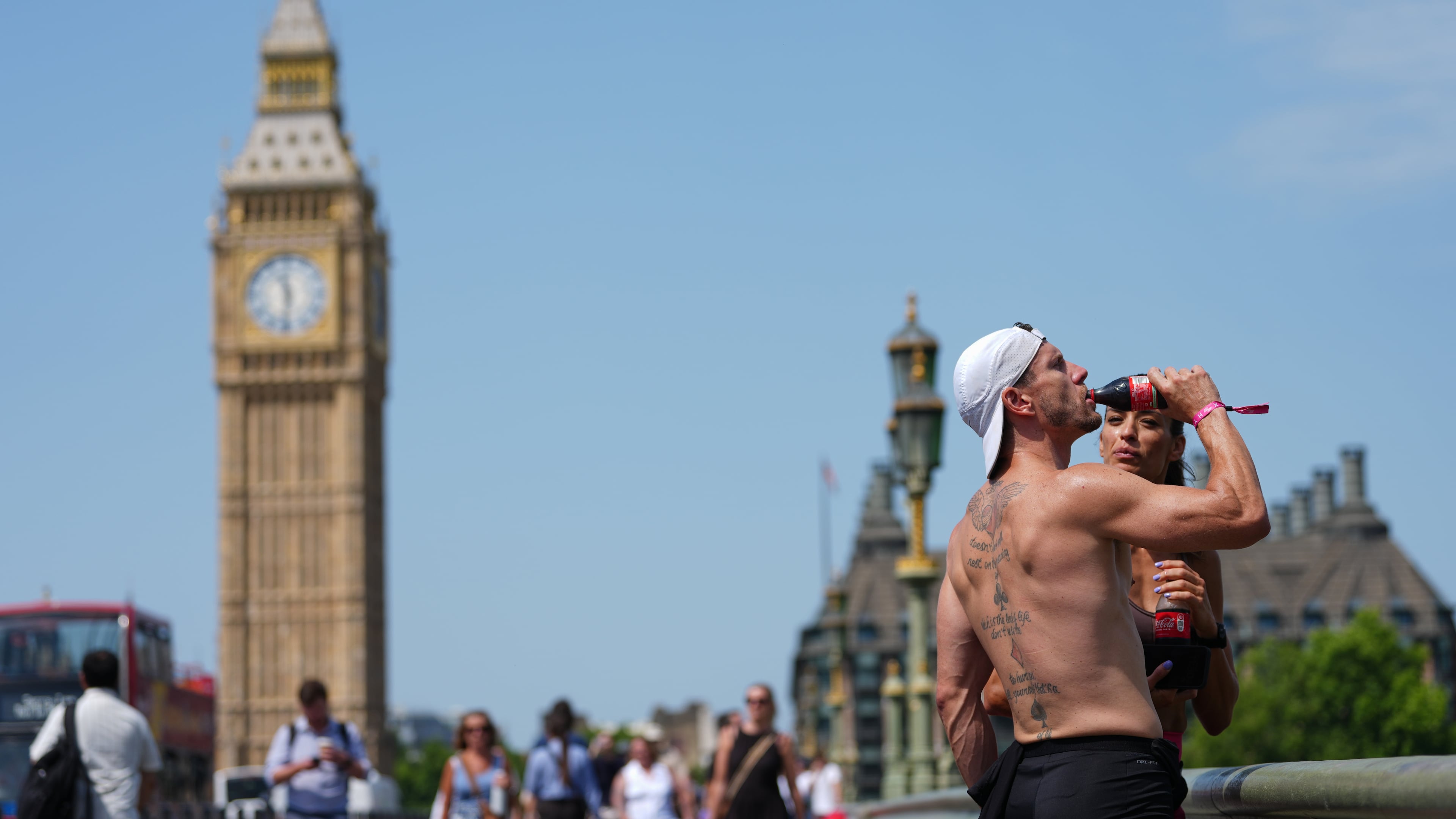 A man drinks on Westminster Bridge in London, as a heat wave is predicted Tuesday, June 23, 2026. (AP Photo/Kirsty Wigglesworth)