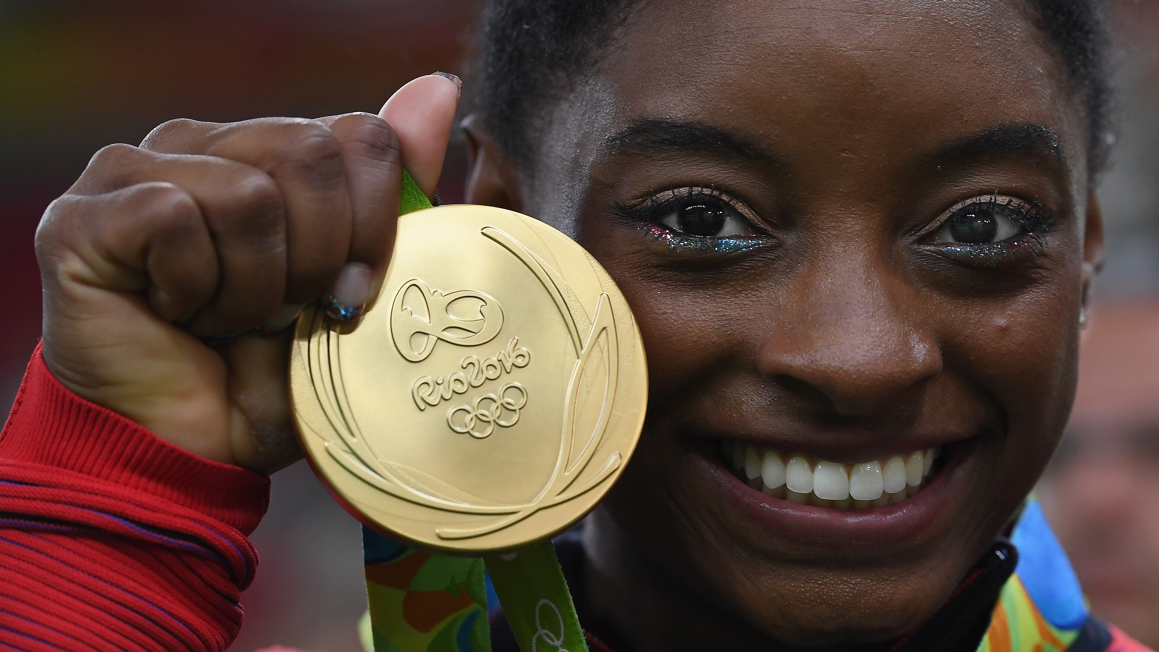 RIO DE JANEIRO, BRAZIL - AUGUST 09: Simone Biles of the United States poses for photographs with her gold medal after the medal ceremony for the Artistic Gymnastics Women's Team on Day 4 of the Rio 2016 Olympic Games at the Rio Olympic Arena on August 9, 2016 in Rio de Janeiro, Brazil. (Photo by Laurence Griffiths/Getty Images)