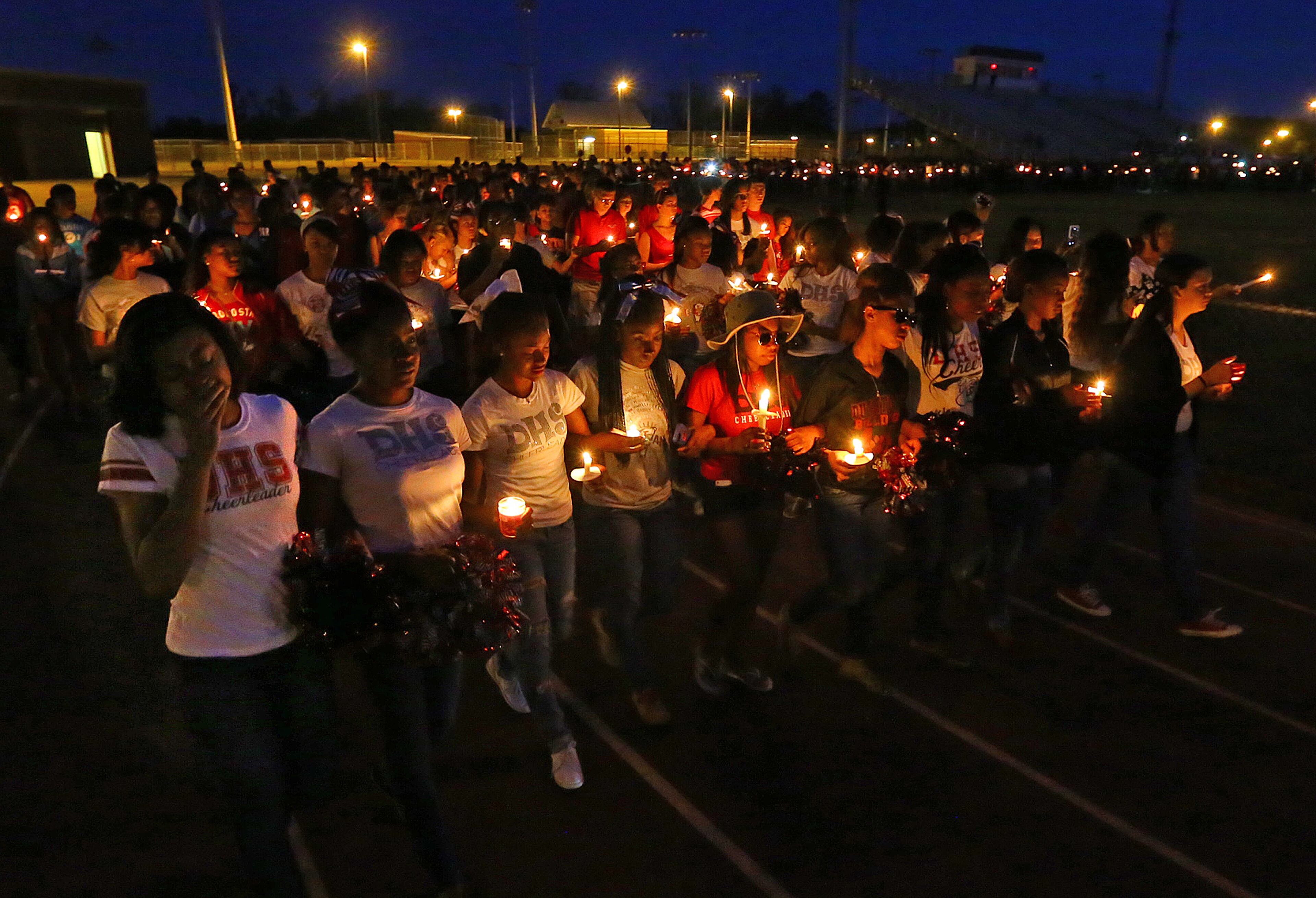 Cheerleaders lead a candlelight vigil on a lap around the track at the conclusion of a vigil to remember 16-year-old Henry County girl Jasmine Poole in the football stadium at Dutchtown High School on Thursday, May 8, 2014, in Hampton. Poole, who was a cheerleader at the school, was killed and two other teens injured in a Wednesday afternoon wreck. CURTIS COMPTON / CCOMPTON@AJC.COM