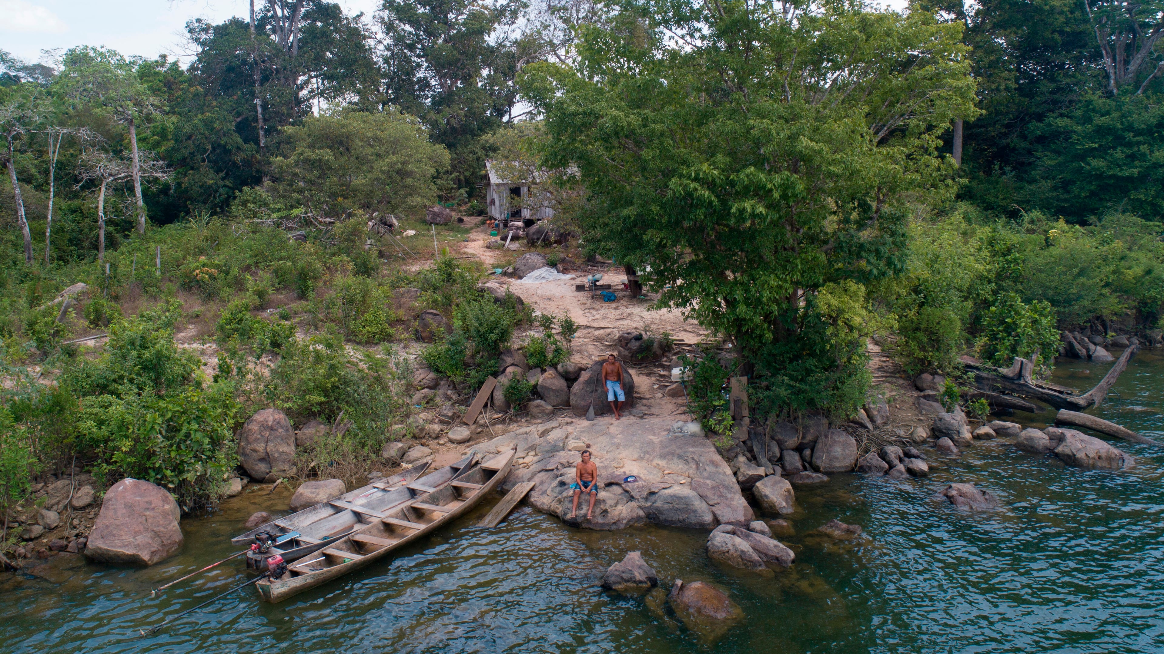 FILE - A fisher sits outside his home on the banks of the Xingu River, near the Belo Monte hydroelectric dam in Altamira, Para state, Brazil, Sept. 6, 2019. (AP Photo/Andre Penner, File)