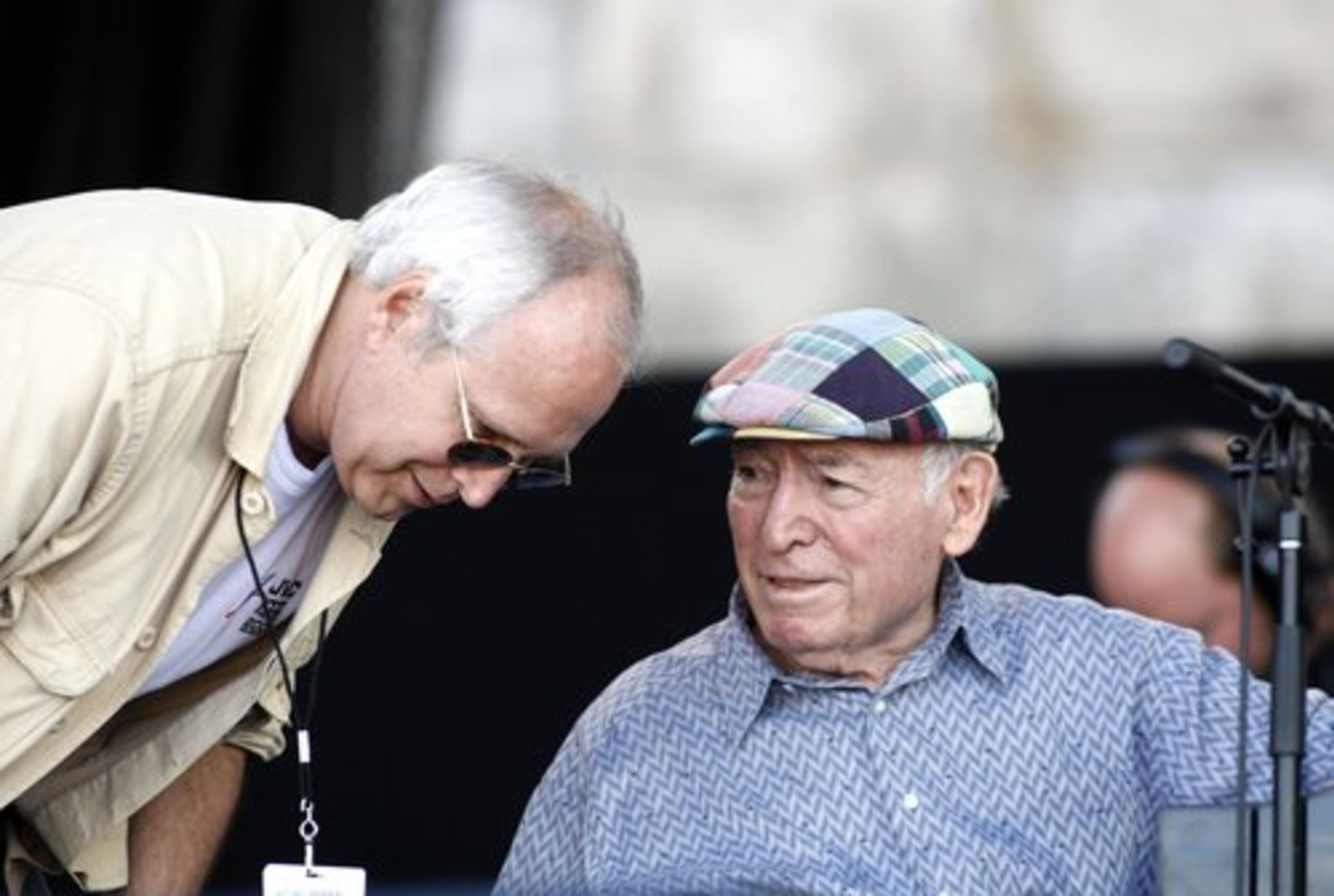Comic actor Chevy Chase leans in to listen to pianist George Wein before introducing Wein and his Newport All Stars Sunday.