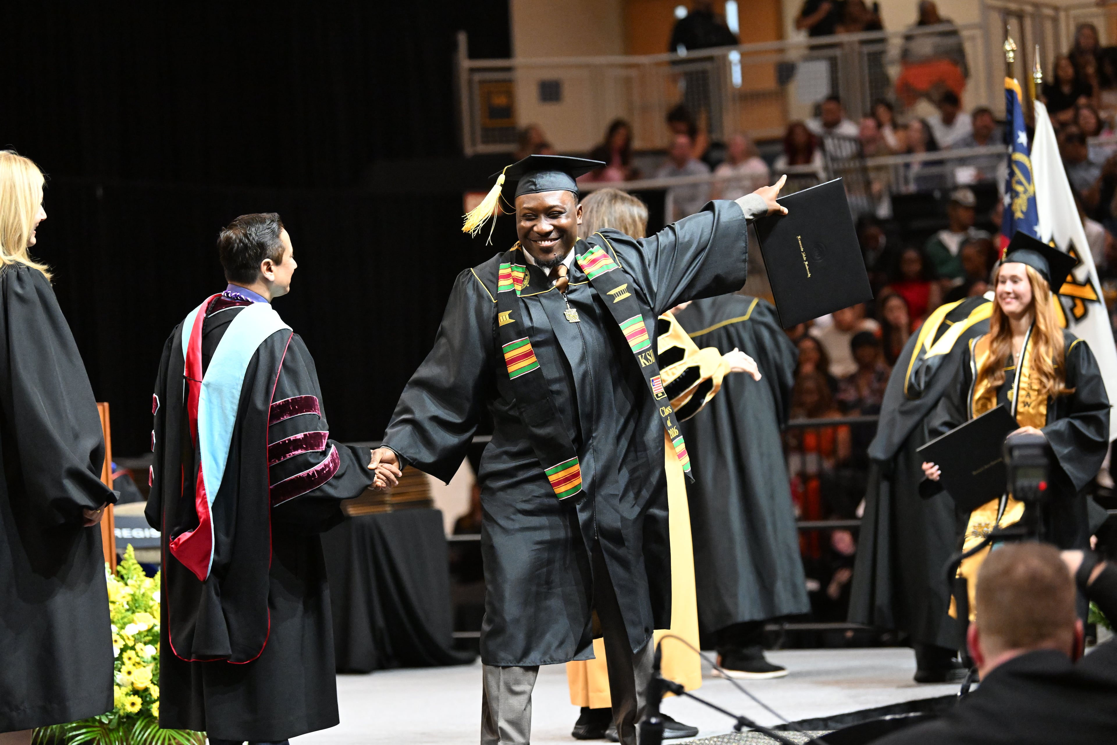 KSU graduate express their excitement is a variety of ways during commencement. (Hyosub Shin/AJC)