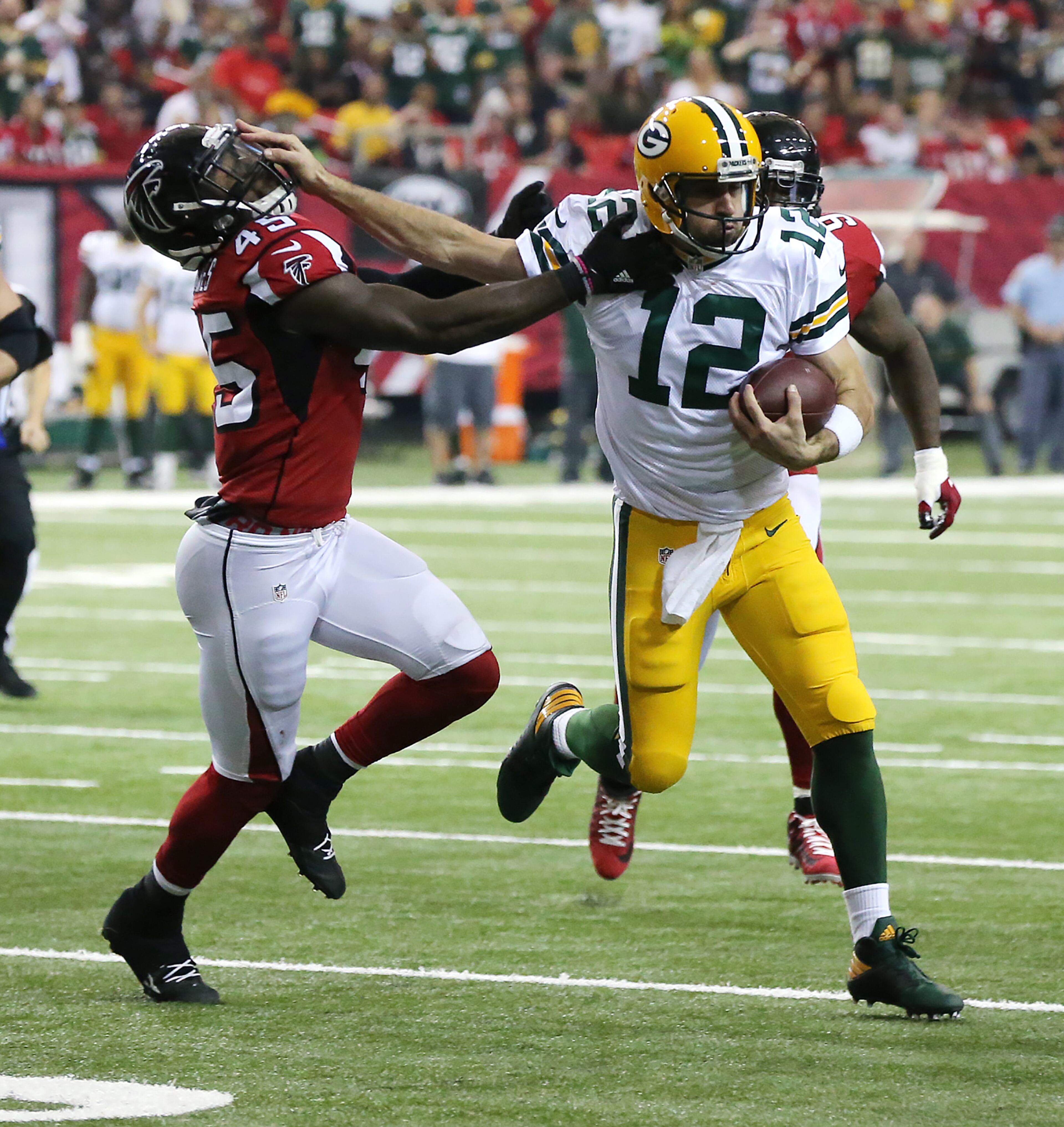 October 30, 2016 ATLANTA: Packers Aaron Rodgers stiff arms Falcons defender Deion Jones who holds on to make the tackle on a quarterback keeper during the first half in an NFL football game on Sunday, Oct. 30, 2016, in Atlanta. Curtis Compton /ccompton@ajc.com