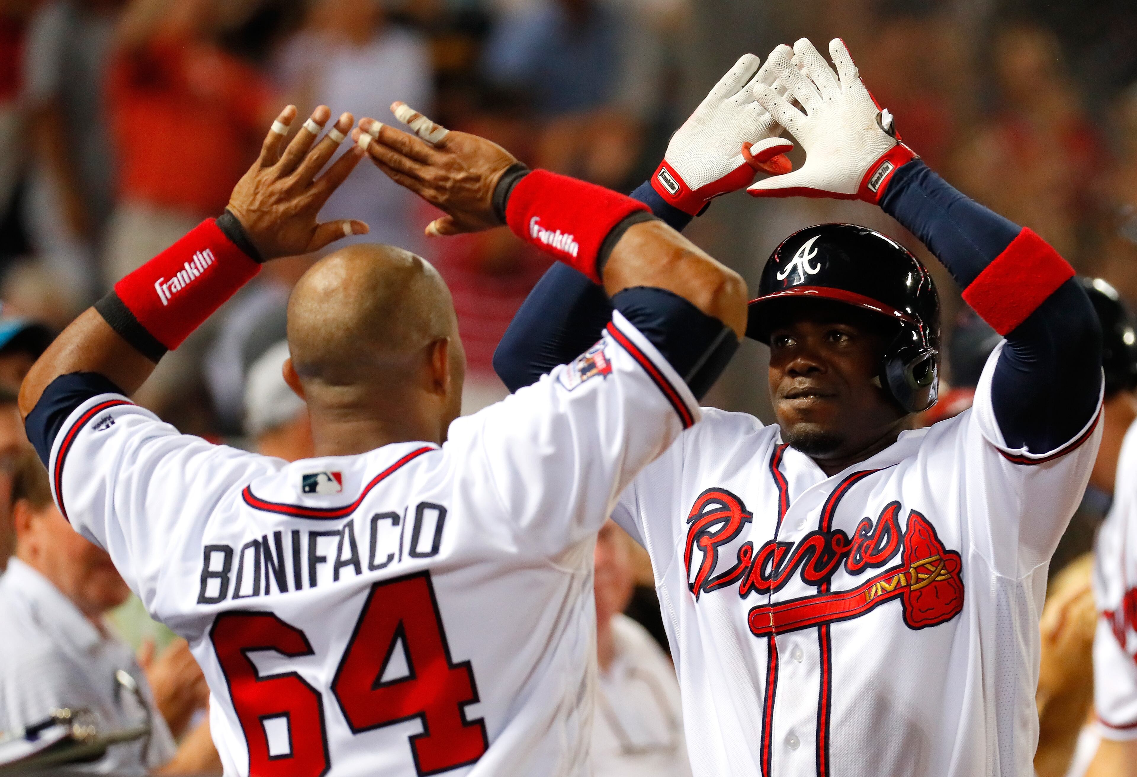 ATLANTA, GA - JUNE 23: Adonis Garcia #13 of the Atlanta Braves reacts with Emilio Bonifacio #64 after hitting a two-run homer to score Freddie Freeman #5 in the eighth inning against the New York Mets at Turner Field on June 23, 2016 in Atlanta, Georgia. (Photo by Kevin C. Cox/Getty Images)