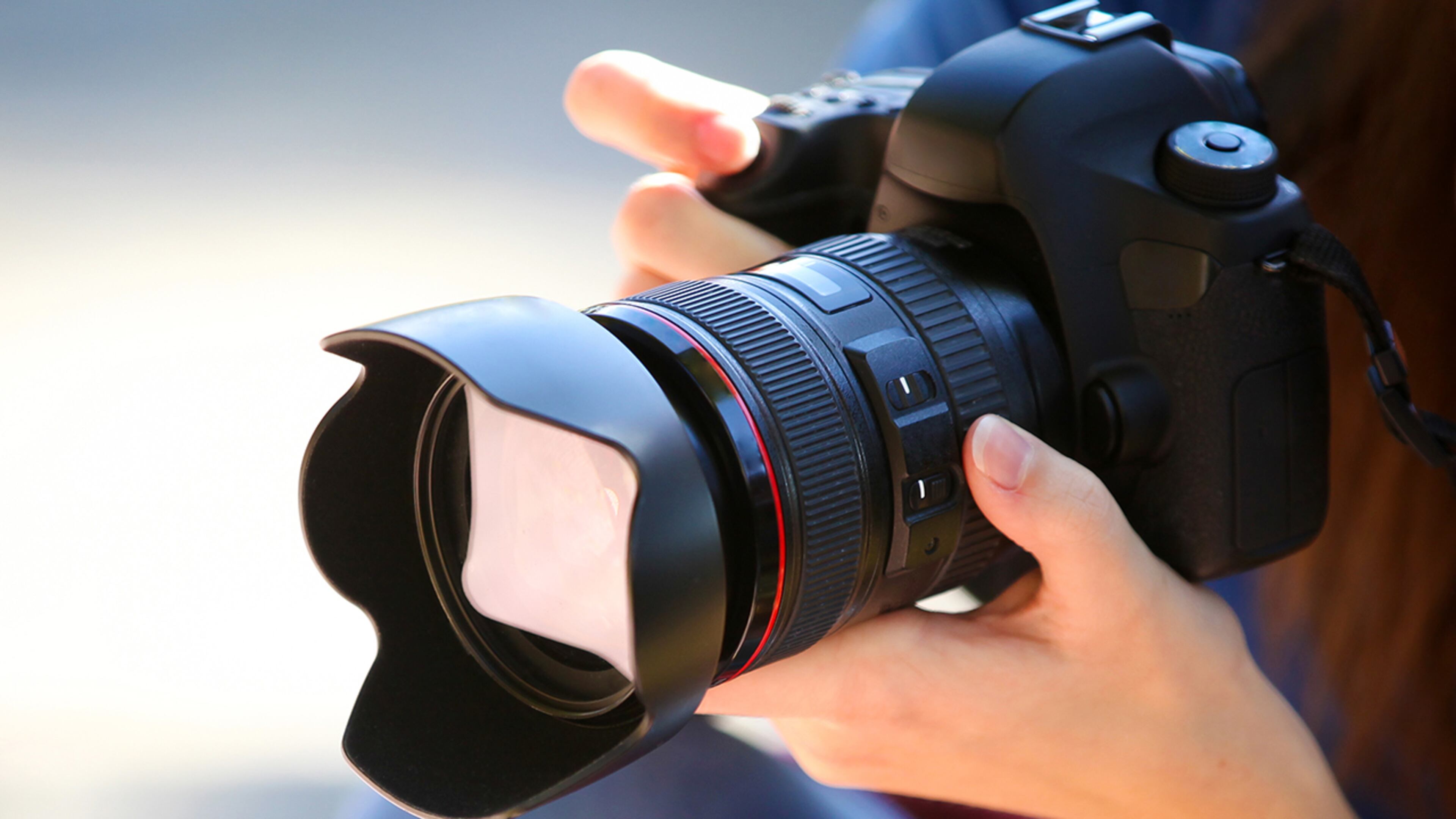 A Young Woman Holding a Full Frame Camera.
