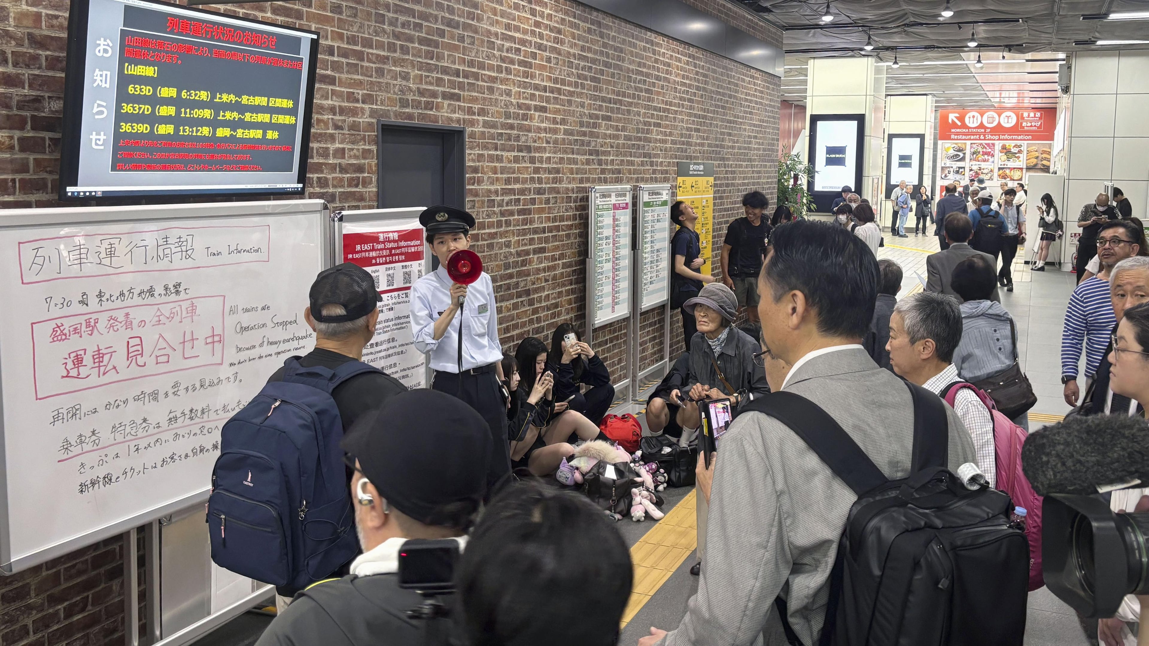 A station clerk of the East Japan Railway Co., provides an update about train services which were suspended due to an earthquake at JR Morioka station in Morioka, northern Japan, Thursday, July 25, 2026. (Kyodo News via AP)
