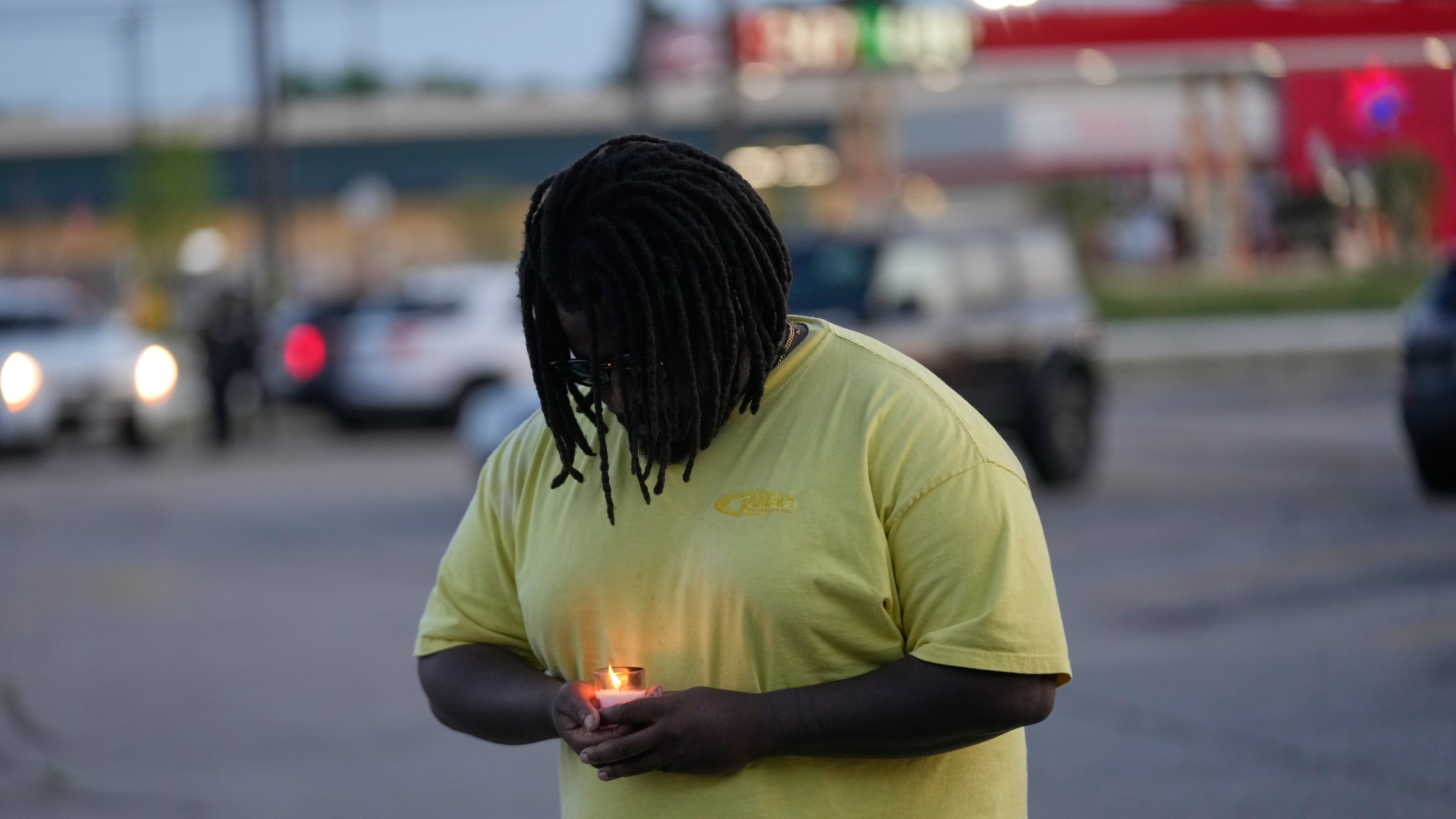 A man holds a candle during a prayer vigil for the victims of a mass shooting earlier in the day, Sunday, April 19, 2026, in Shreveport, La. (AP Photo/Gerald Herbert)