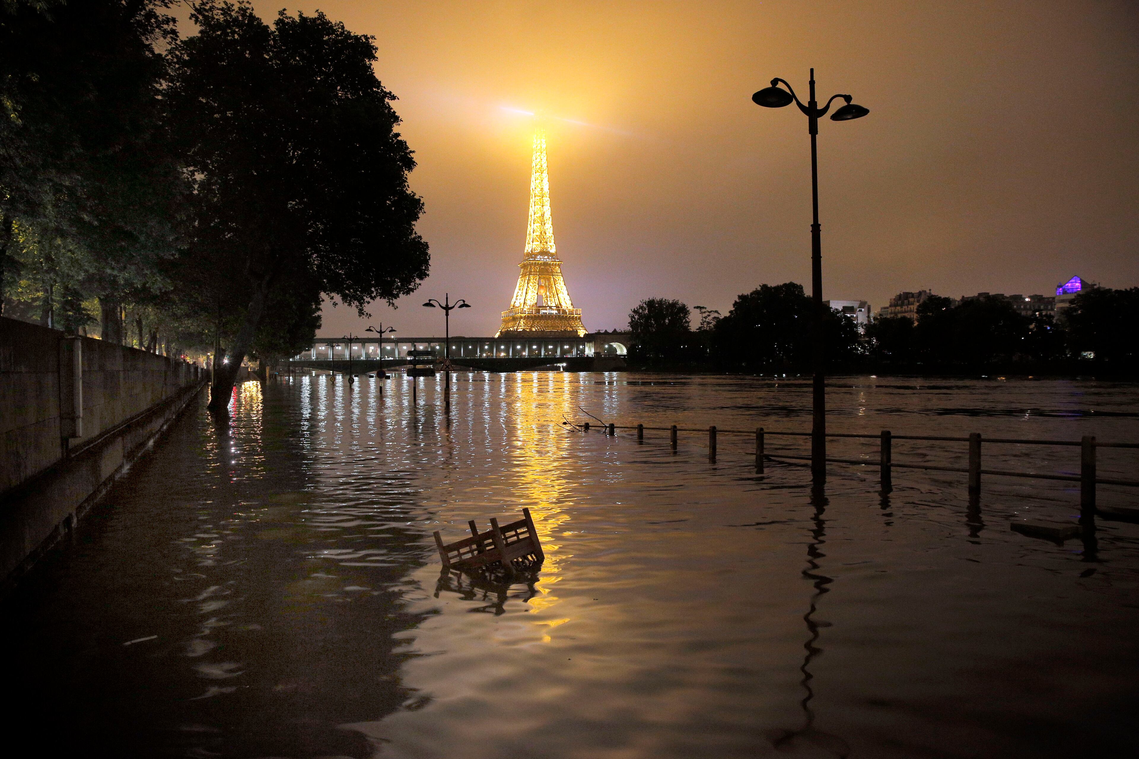 View of the flooded banks of the river Seine in front of the Eiffel tower in Paris, Friday, June 3, 2016. Both the Louvre and Orsay museums were closed as the Seine, which officials said was at its highest level in nearly 35 years, was expected to peak sometime later Friday. (AP Photo/Christophe Ena)