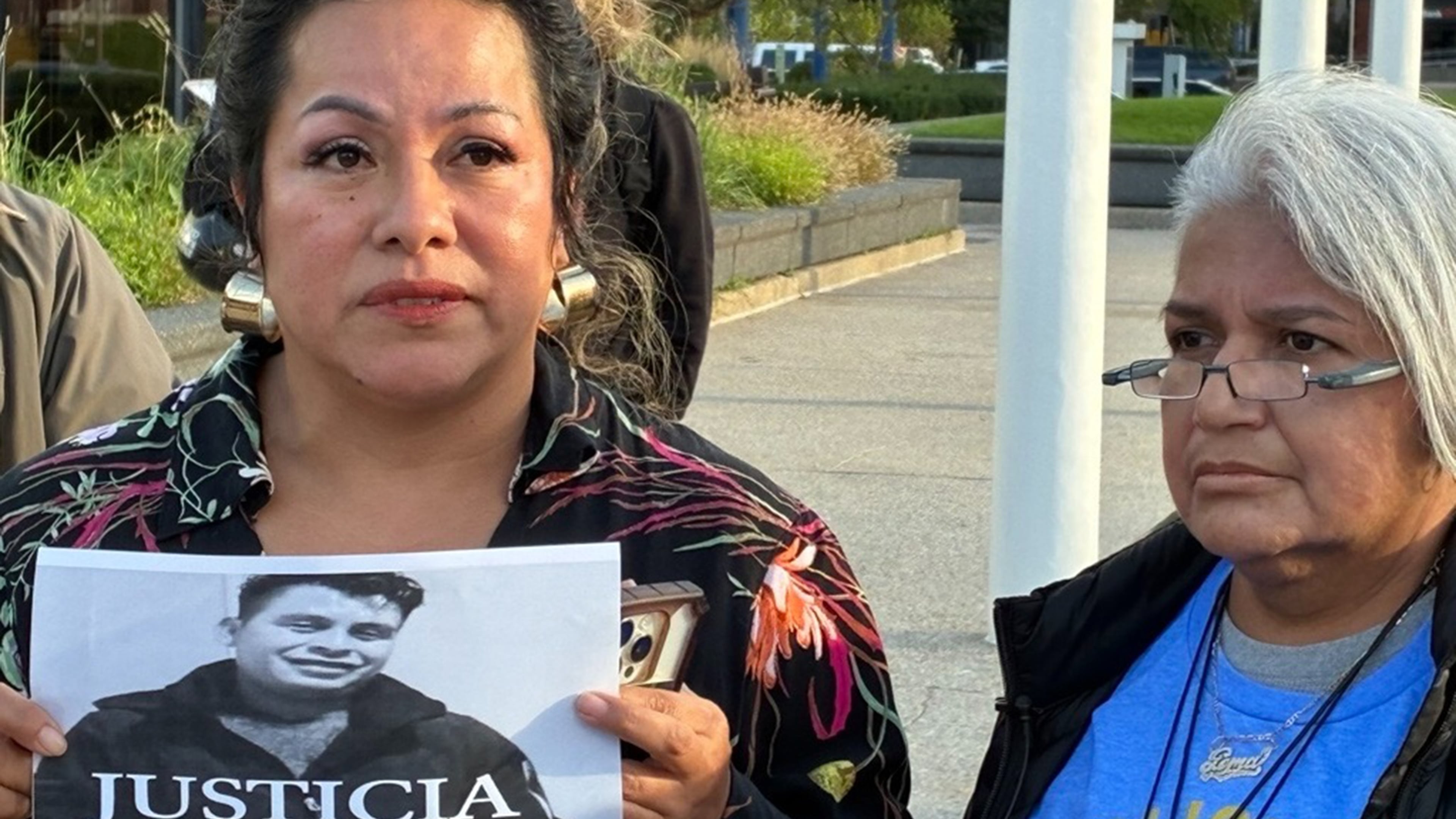 In this photo taken with a smartphone, Karla Barberi, left, and Gema Lowe demand justice Thursday, Sept. 24, 2026, for Mario David Coronado Juarez, who died in a car crash while fleeing ICE officers Sunday, Sept. 20 in Grand Rapids, Ill. (John Agar/The Grand Rapids Press via AP)