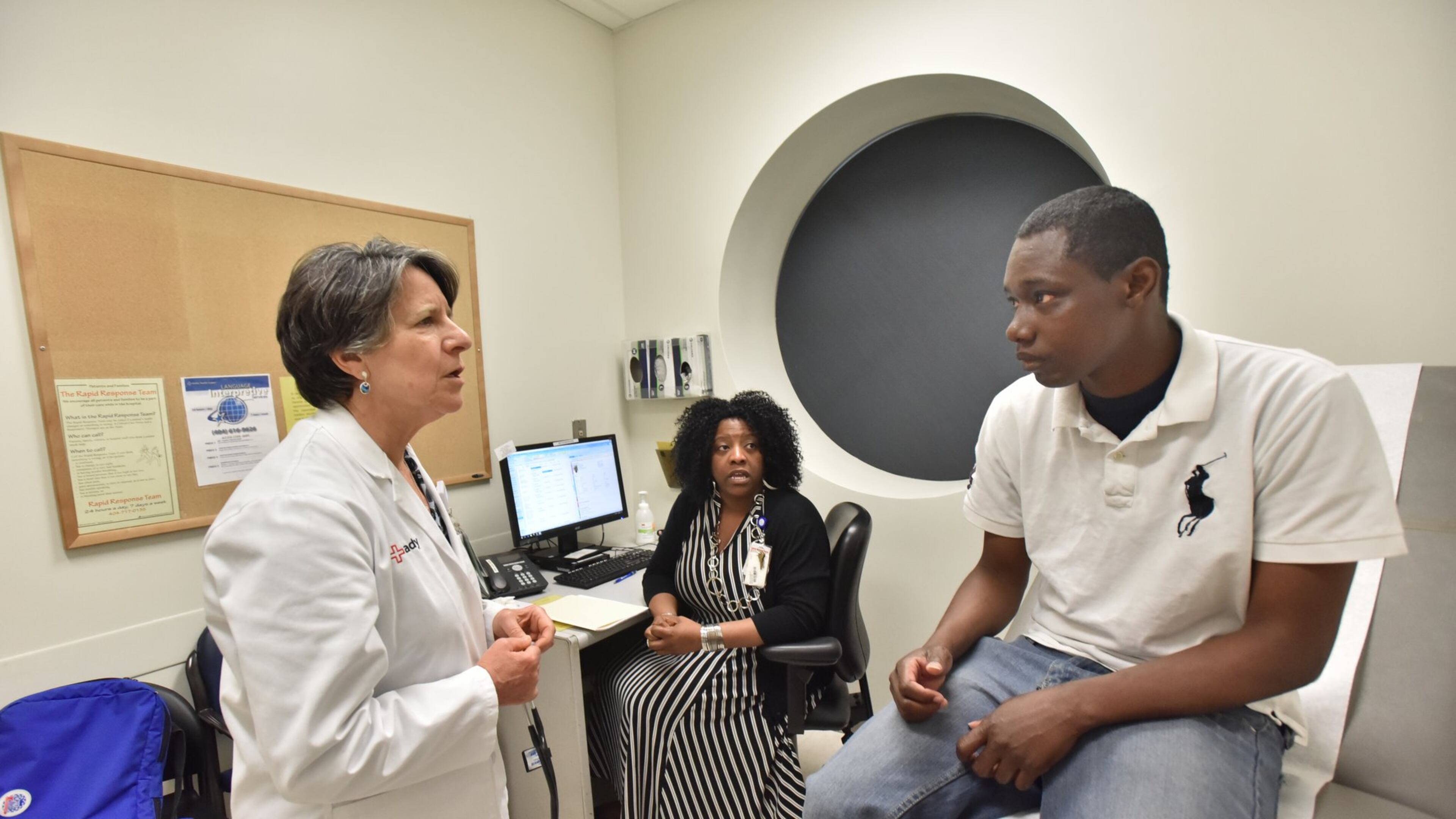 Dr. Claudia Vellozzi, left, and Karen Sutton talk to Alex Harris, a participant in the Chronic Care Clinic program at Grady Memorial Hospital in Atlanta. Vellozzi is the medical director of the clinic that gets doctors, nurses, assistants, pharmacists and community health workers deeply involved in a patient’s situation to reduce visits to the emergency room. Sutton is a licensed clinical social worker in the program. HYOSUB SHIN / HSHIN@AJC.COM