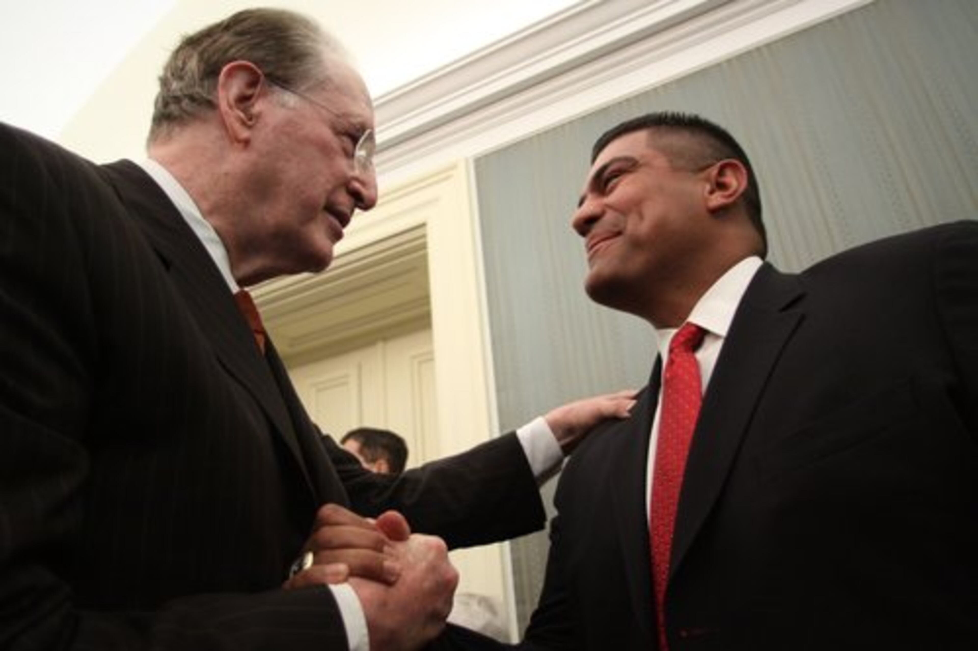 Rockefeller shakes the hand of Braves bullpen coach Eddie Perez.