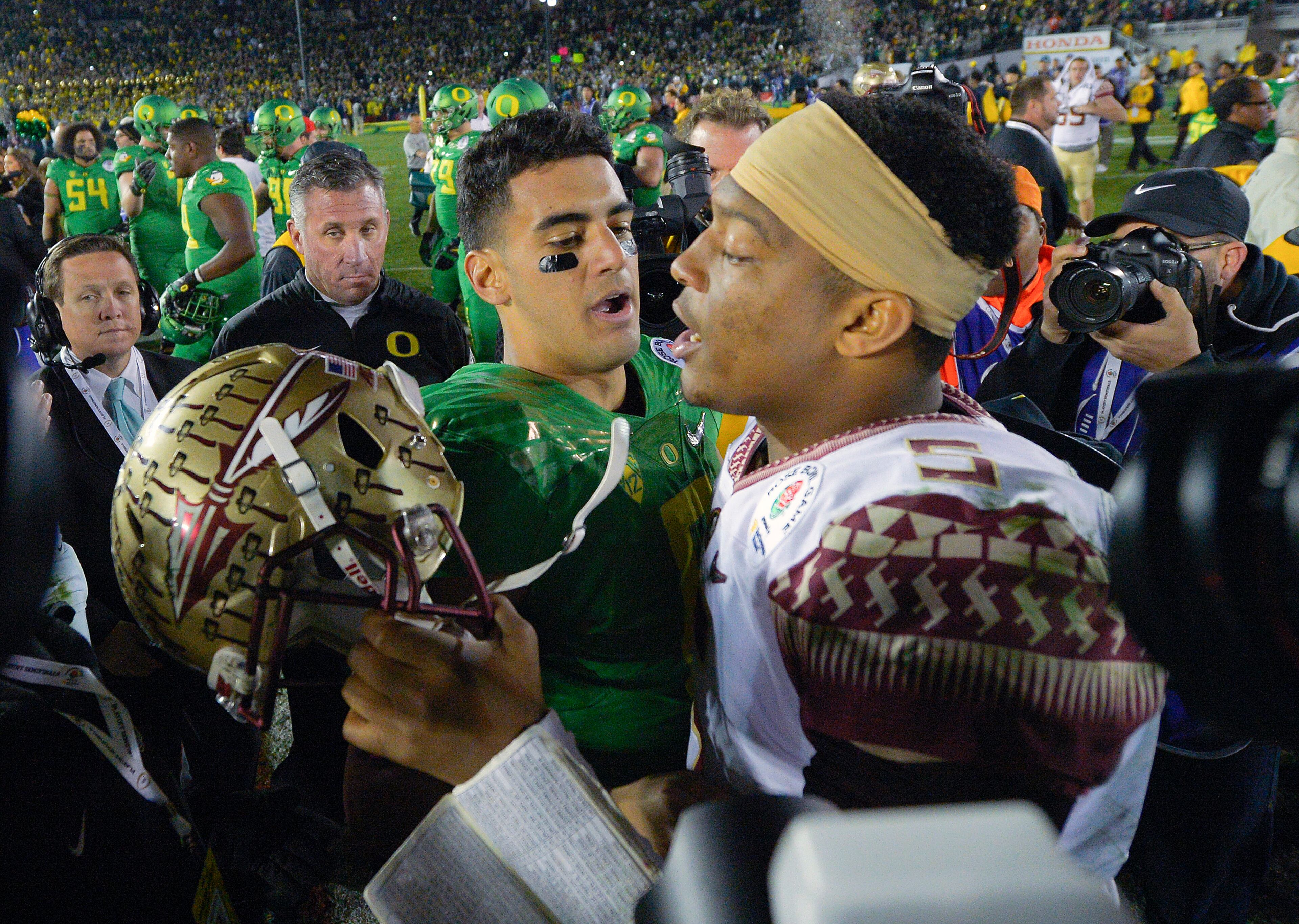Oregon quarterback Marcus Mariota, center left, greets Florida State quarterback Jameis Winston after Oregon's win in the Rose Bowl NCAA college football playoff semifinal, Thursday, Jan. 1, 2015, in Pasadena, Calif. (AP Photo/Mark J. Terrill)