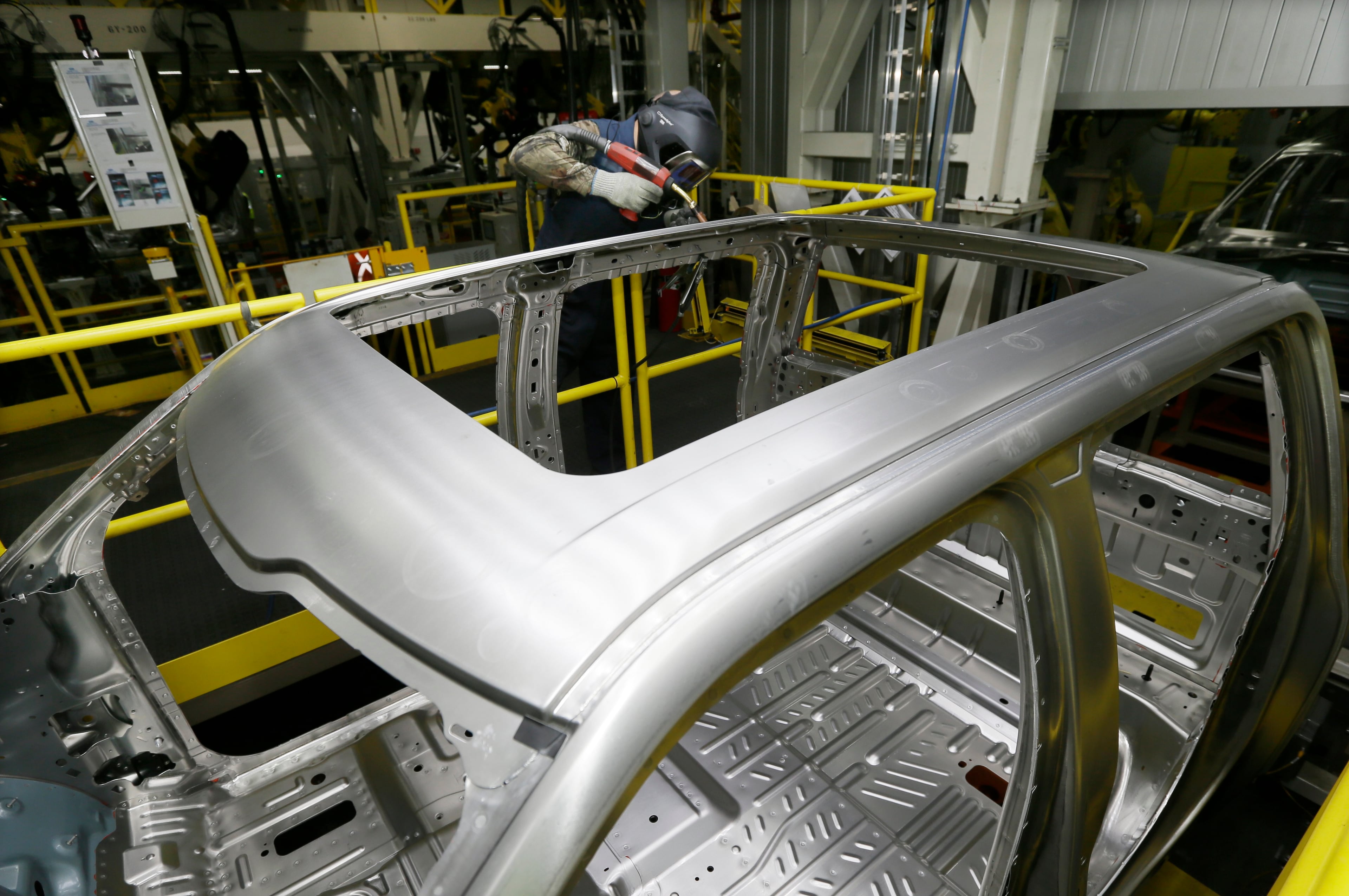 Clark Barton IV works on the new Ford F-150 truck at the Rouge Truck Plant in Dearborn, Mich. It's the automaker's biggest bet in decades: an aluminum-sided F-150 that could set a new industry standard _ or cost the company its pickup truck crown. It will arrive on U.S. dealer lots next month. Aluminum _ which is lighter than steel but just as strong _ isn't new to the auto industry, but this is the first time it will cover the entire body of such a high-volume vehicle. (AP Photo/Carlos Osorio)