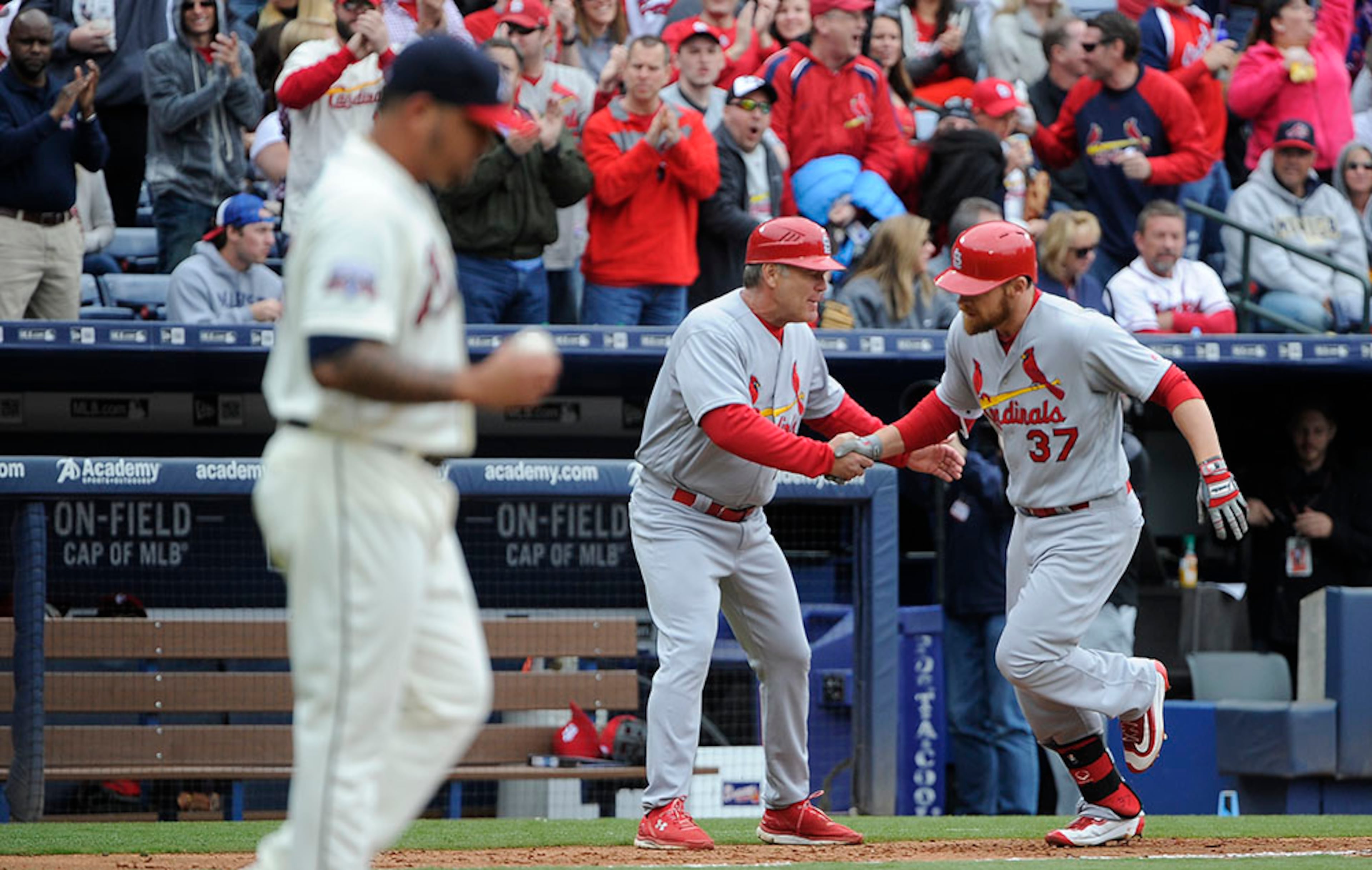 St. Louis Cardinals' Brandon Moss (37) is congratulated by third base coach Chris Maloney after hitting a three-run home run off a pitch by Williams Perez (left) during the third inning Sunday, April 10, 2016, in Atlanta.