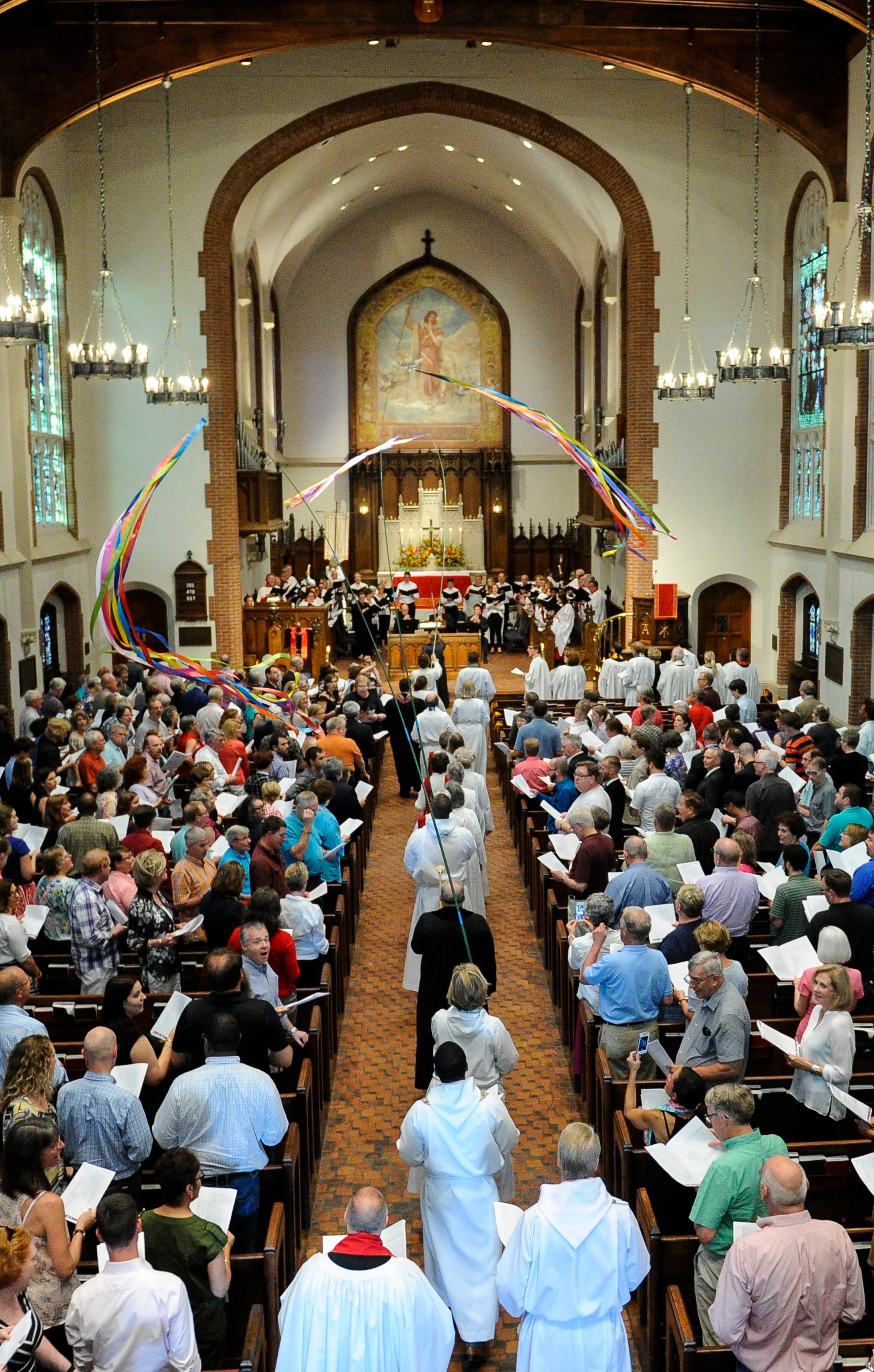 A procession carrying celebration banners sporting the rainbow colors of gay pride file in to start an interfaith service of thanksgiving and celebration of marriage equality, held at St. Luke's Episcopal Church in Atlanta, on the same day the nations Supreme Court ruled same sex marriage legal, Friday, June 26, 2015. (Photo/John Amis)